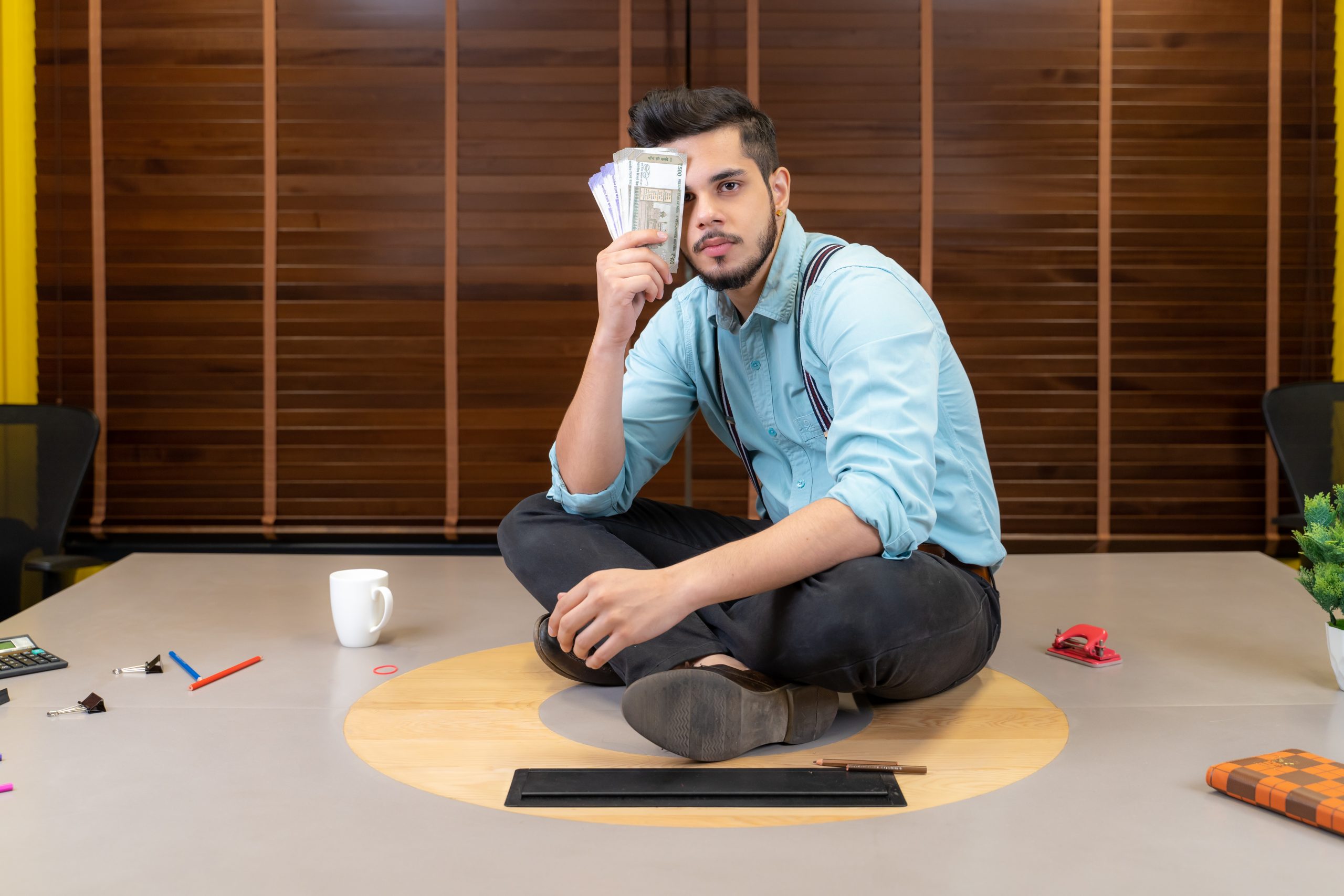 Young male with money in office