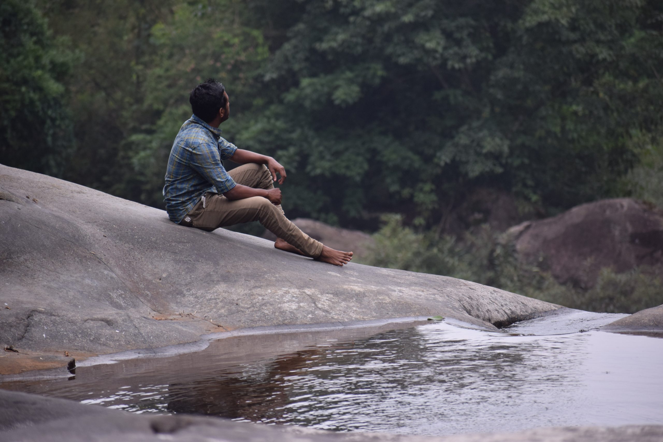 man sitting on rock