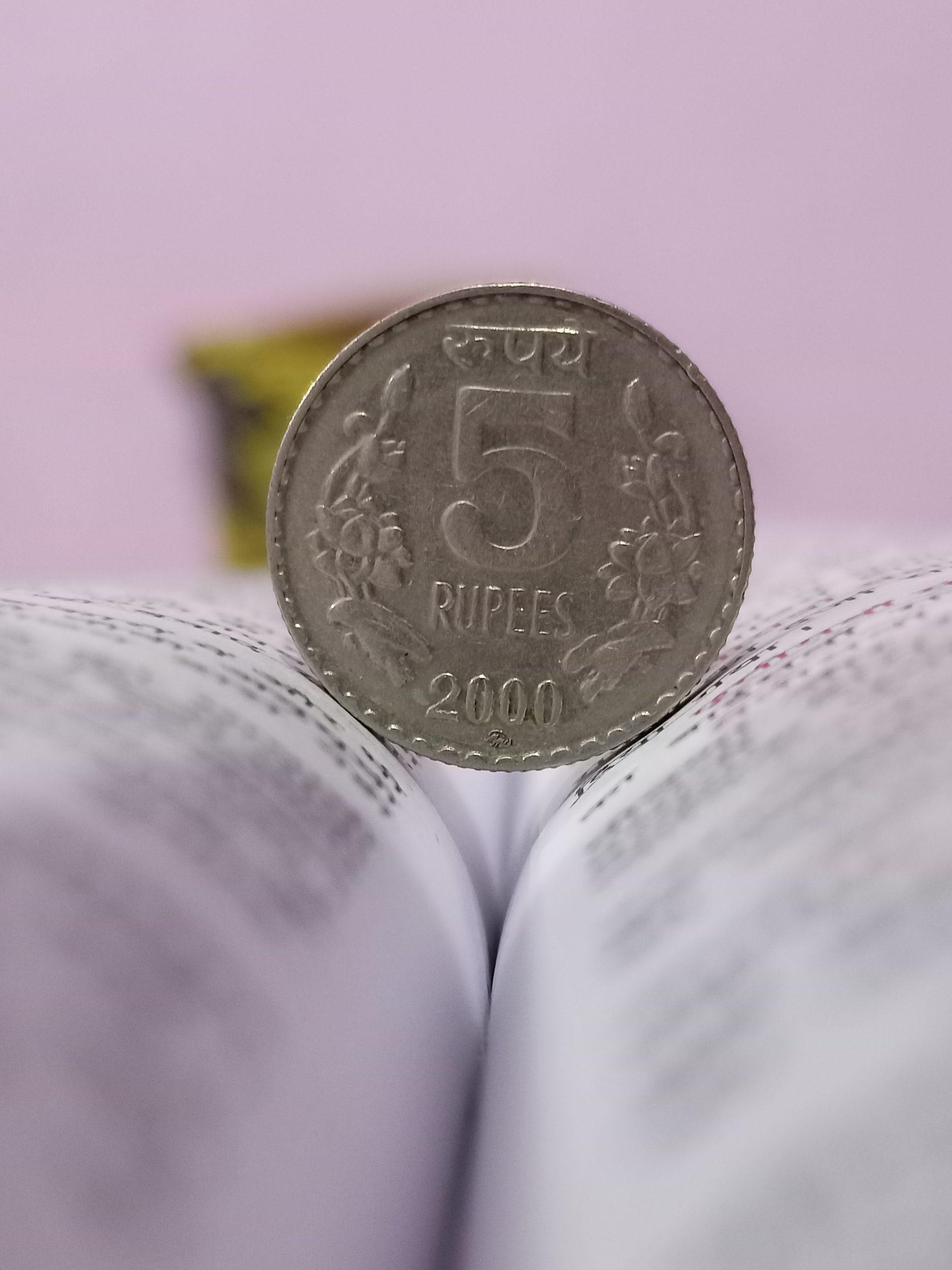 5 rupee coin on a book