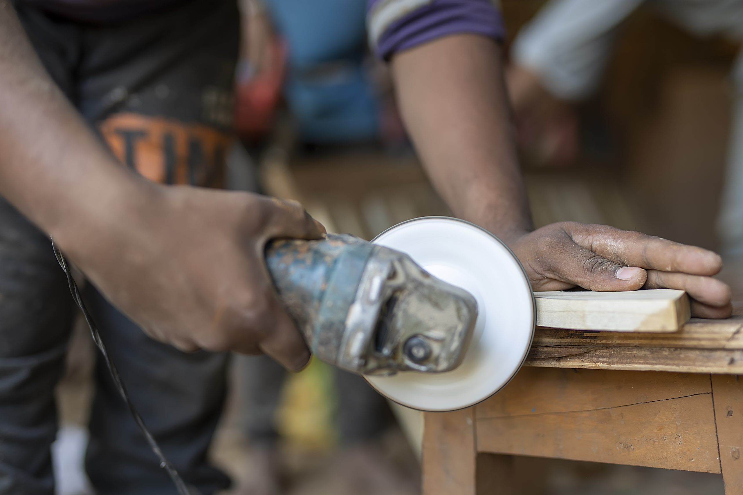 A carpenter cutting a wooden piece