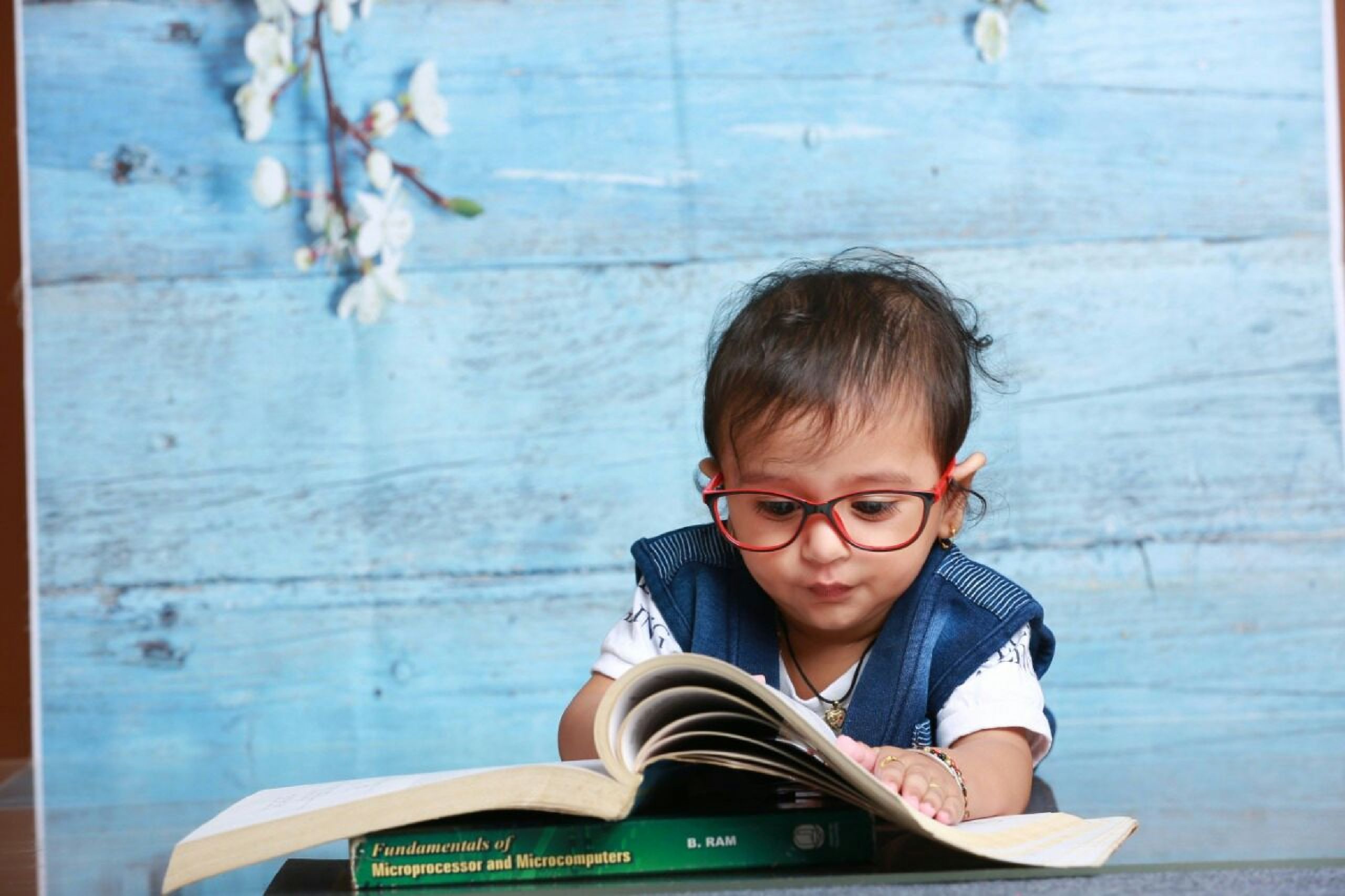 kid with spectacles reading book