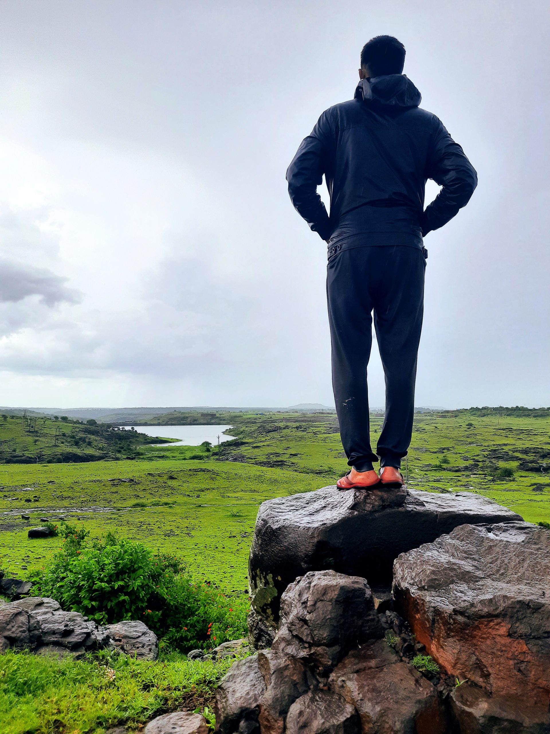 man admiring the view standing on a rock