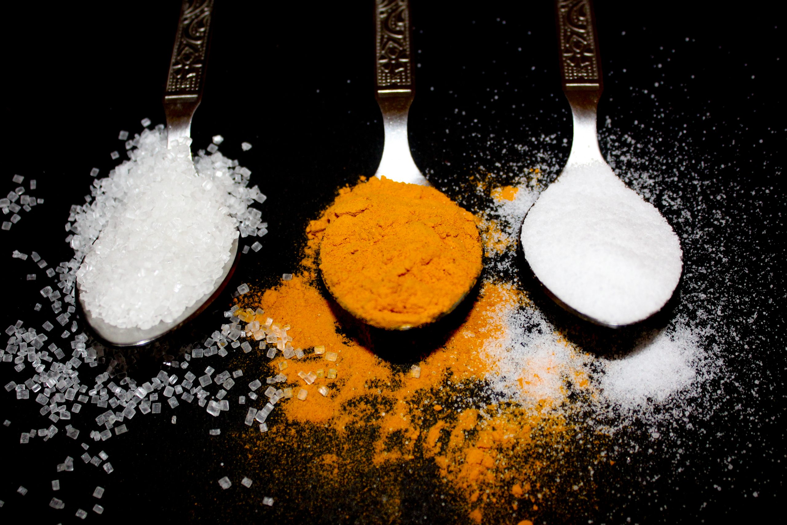 salt, sugar and turmeric in spoons