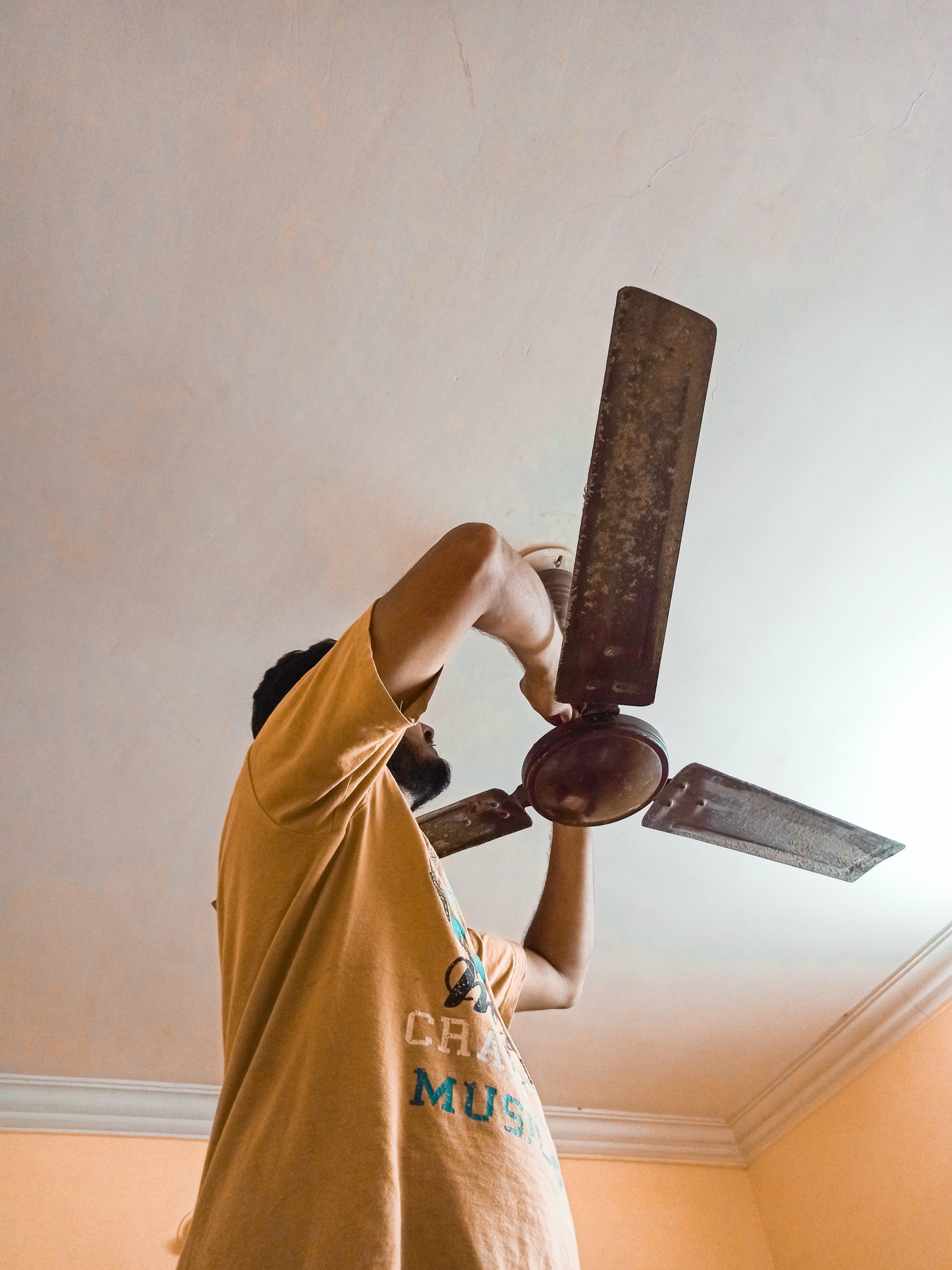 An electrician repairing ceiling fan