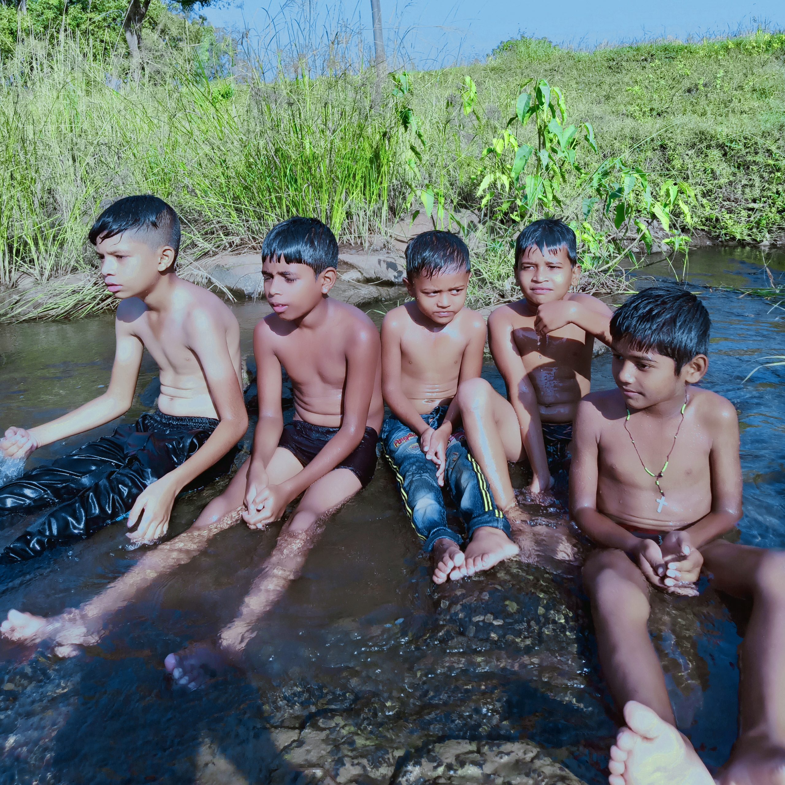 Little boys bating in shallow water river