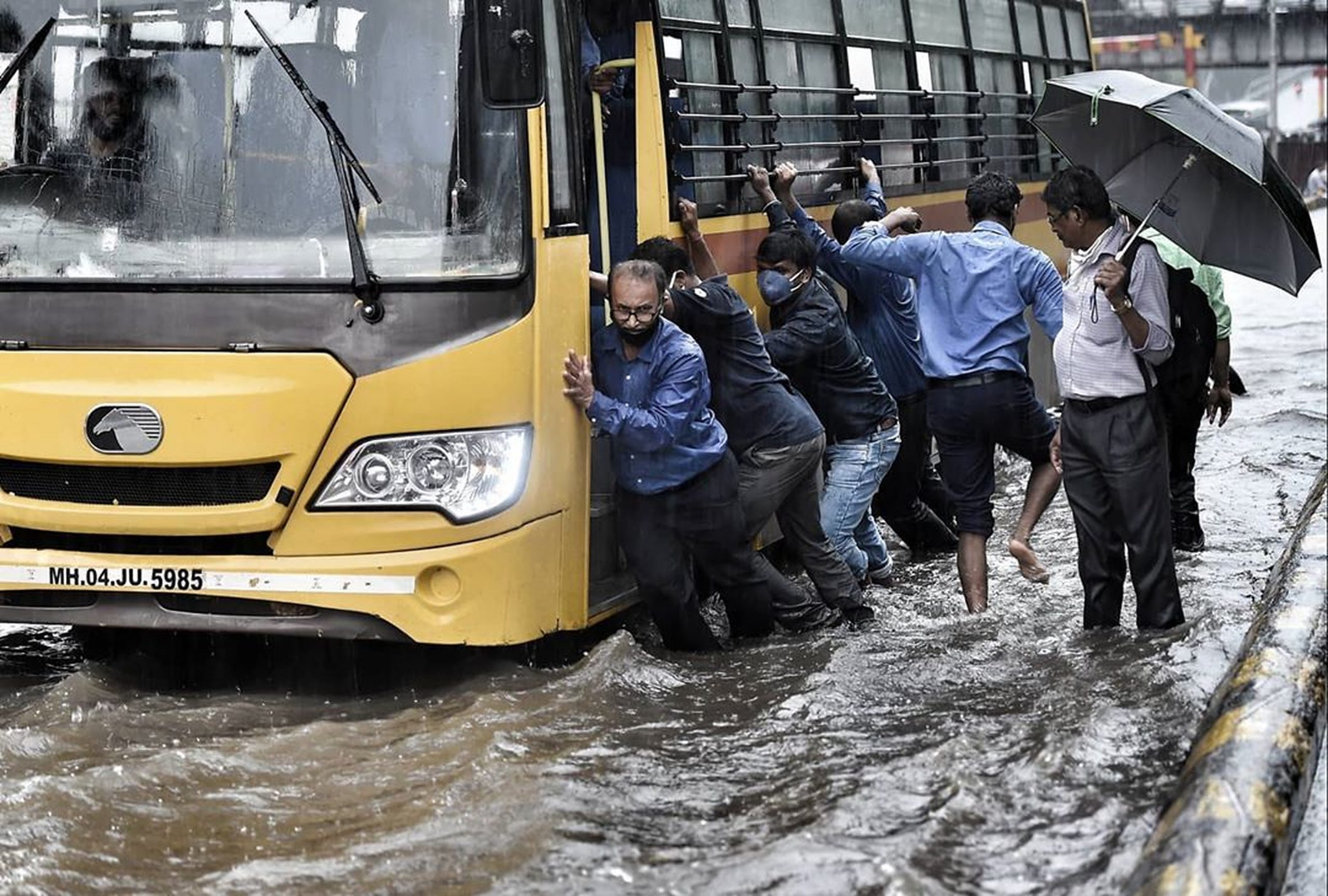 people pushing bus in flood