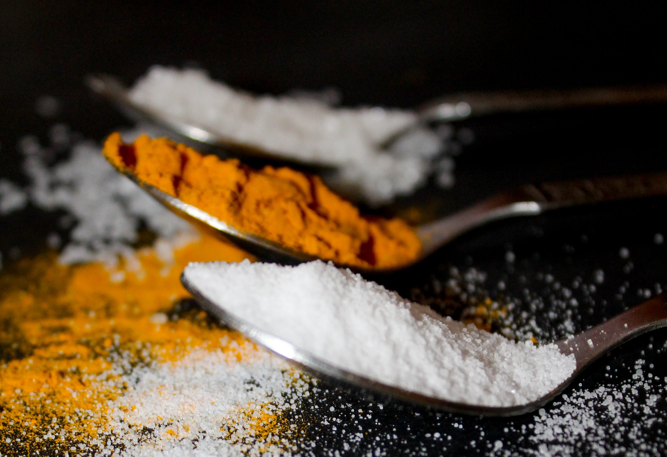 Salt and turmeric powder in spoons