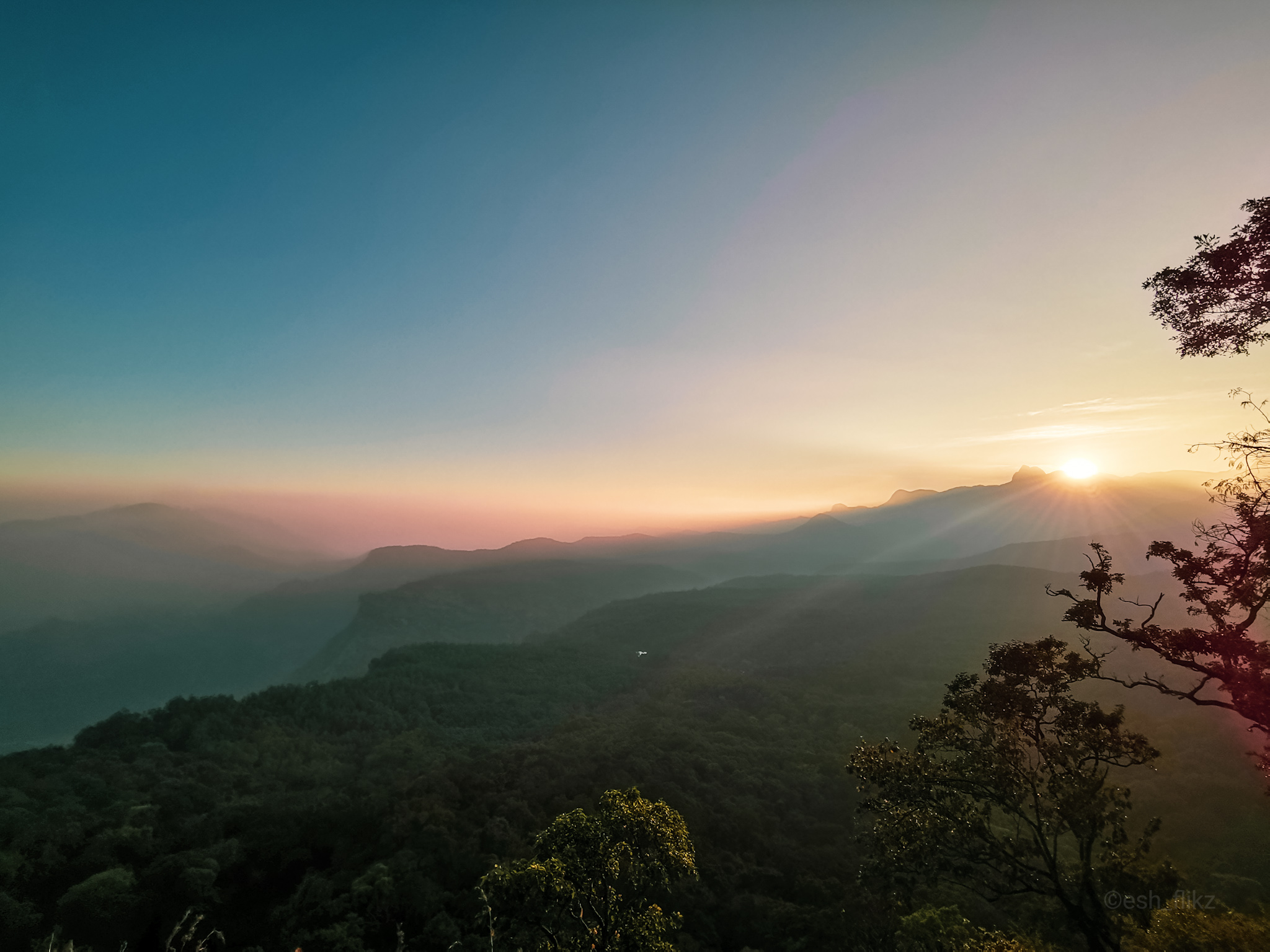 sun setting behind the hills