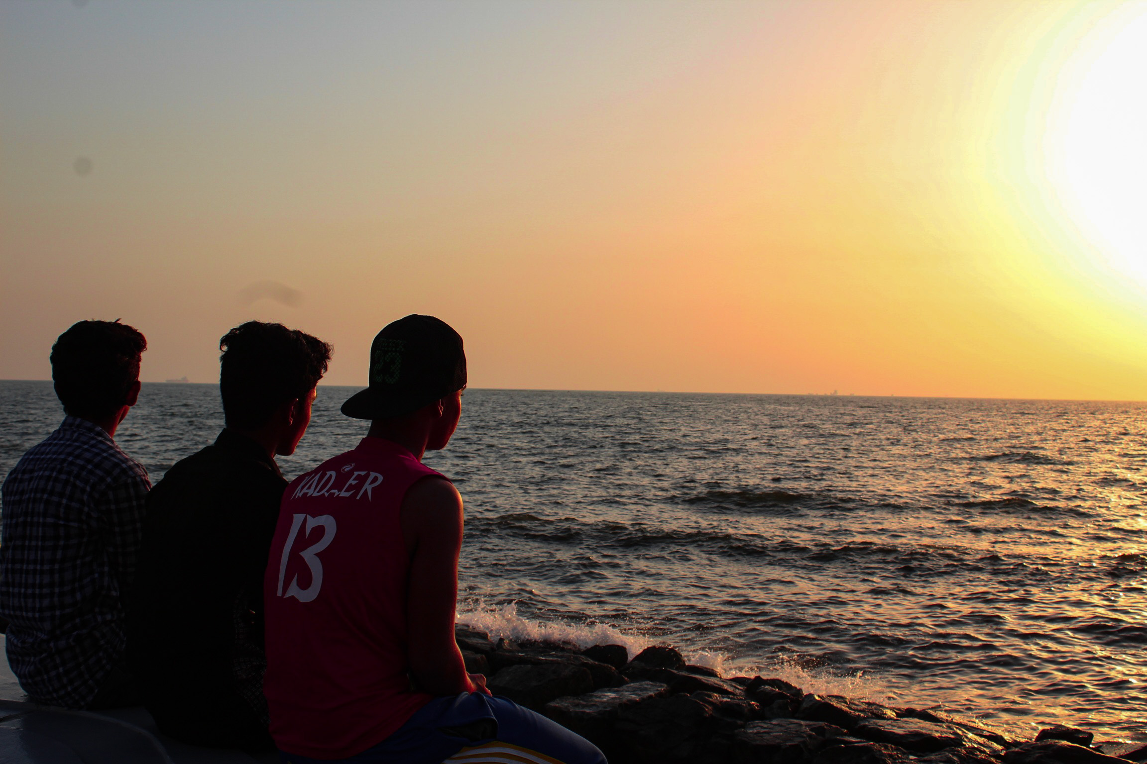 boys watching sunset at the sea