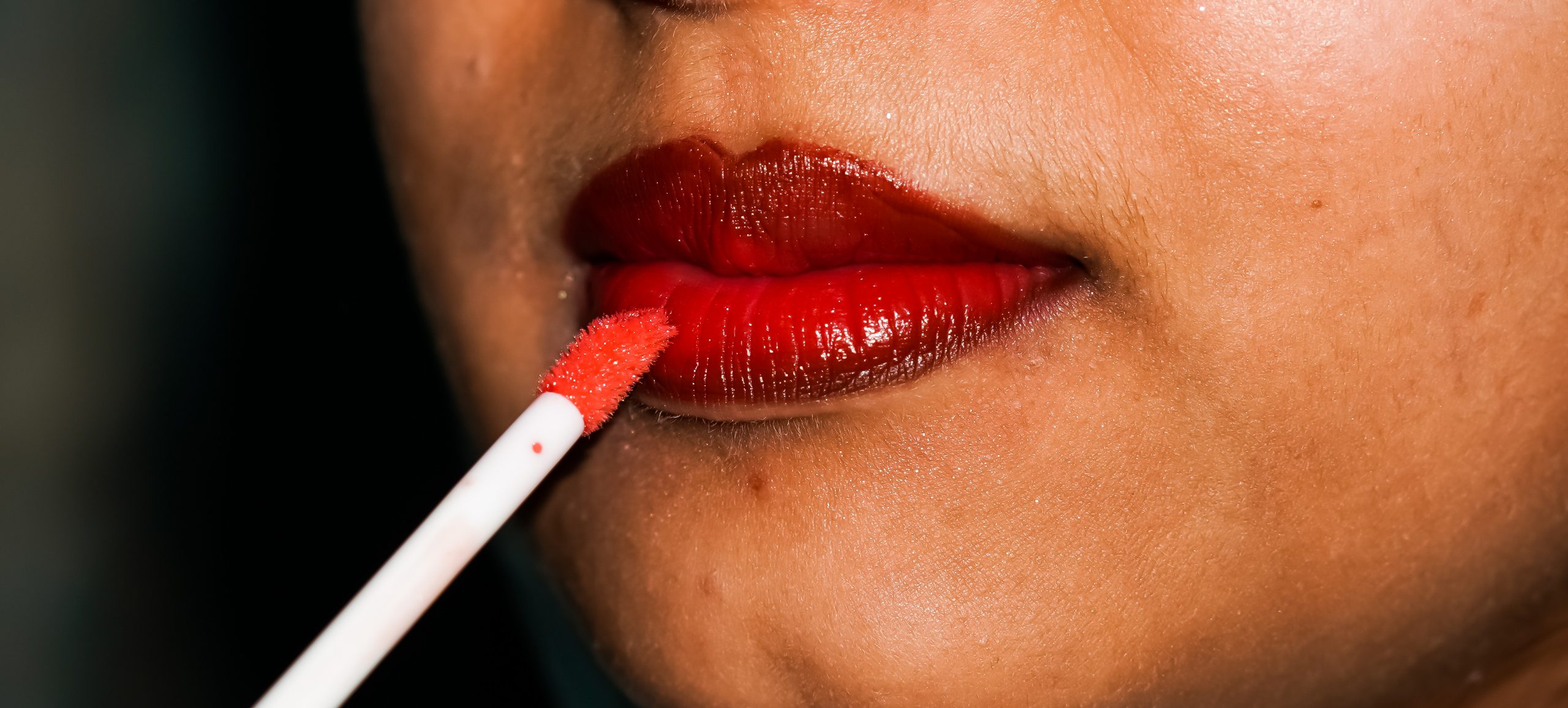 A girl applying, color on lips