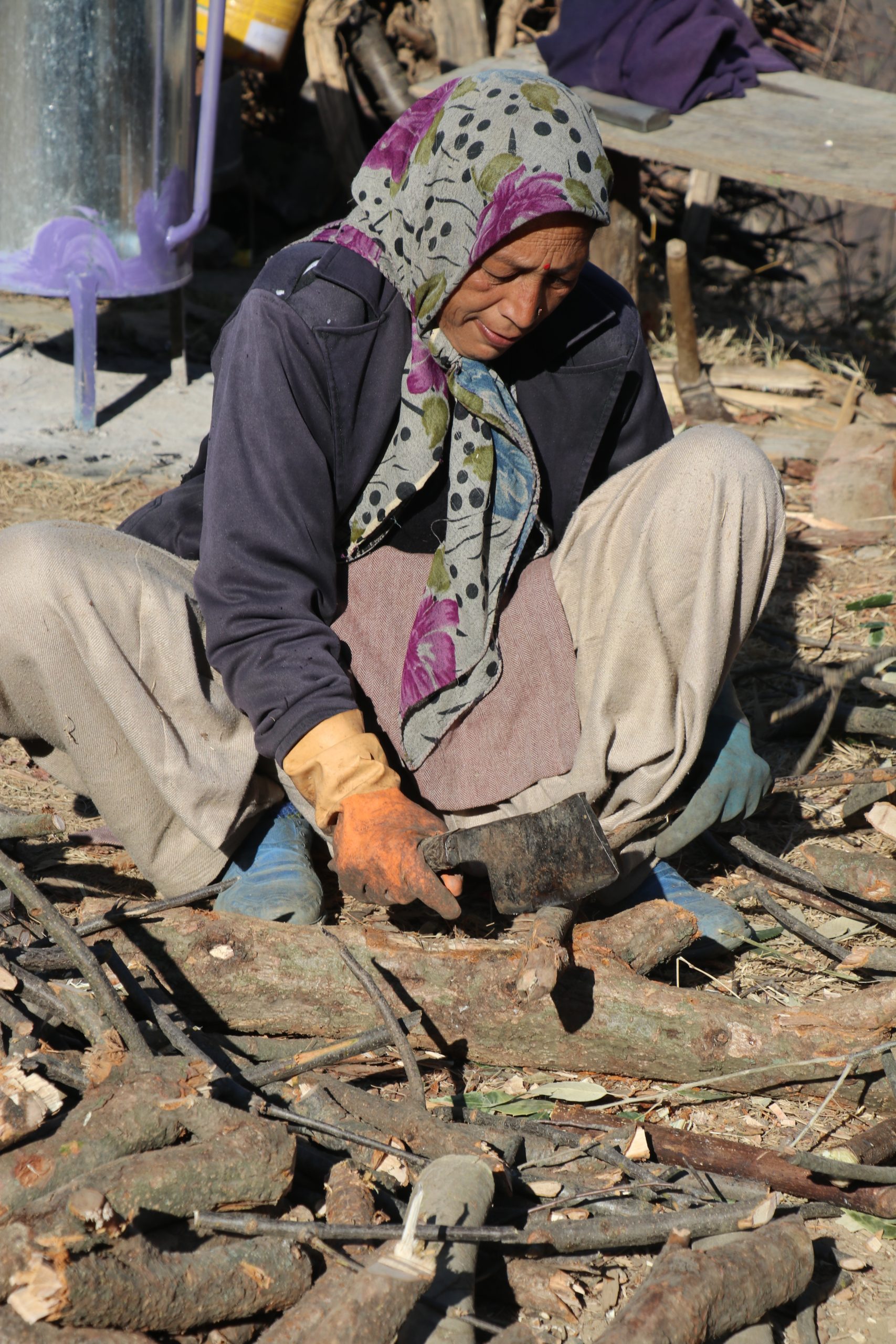 A village woman cutting woods with a blade