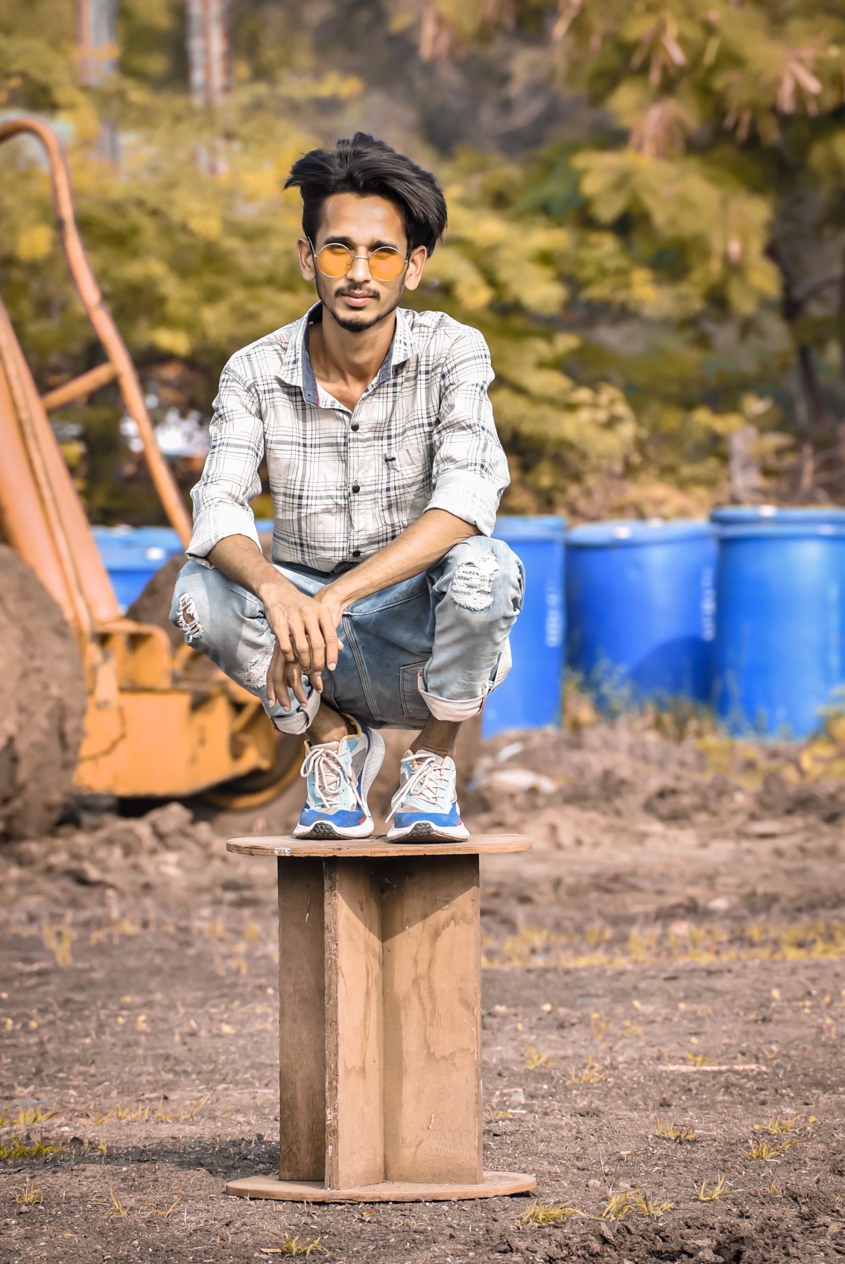 A boy sit on a wood piece