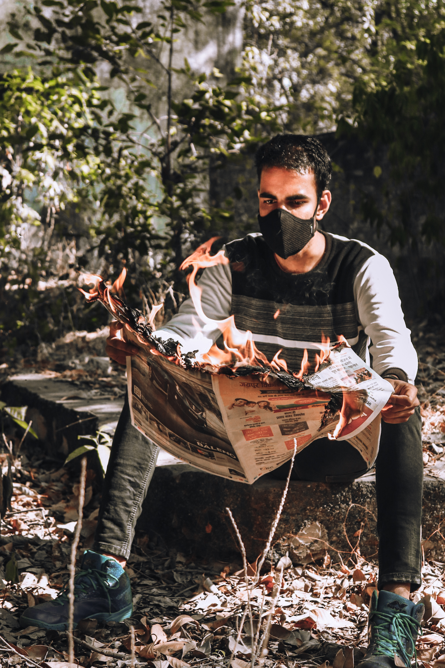 Boy holding burning newspaper