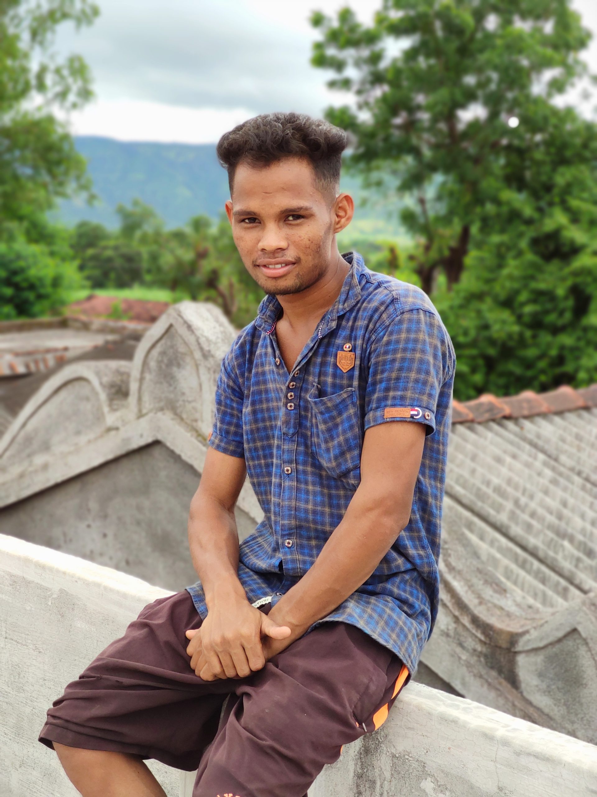 Boy sitting on house roof