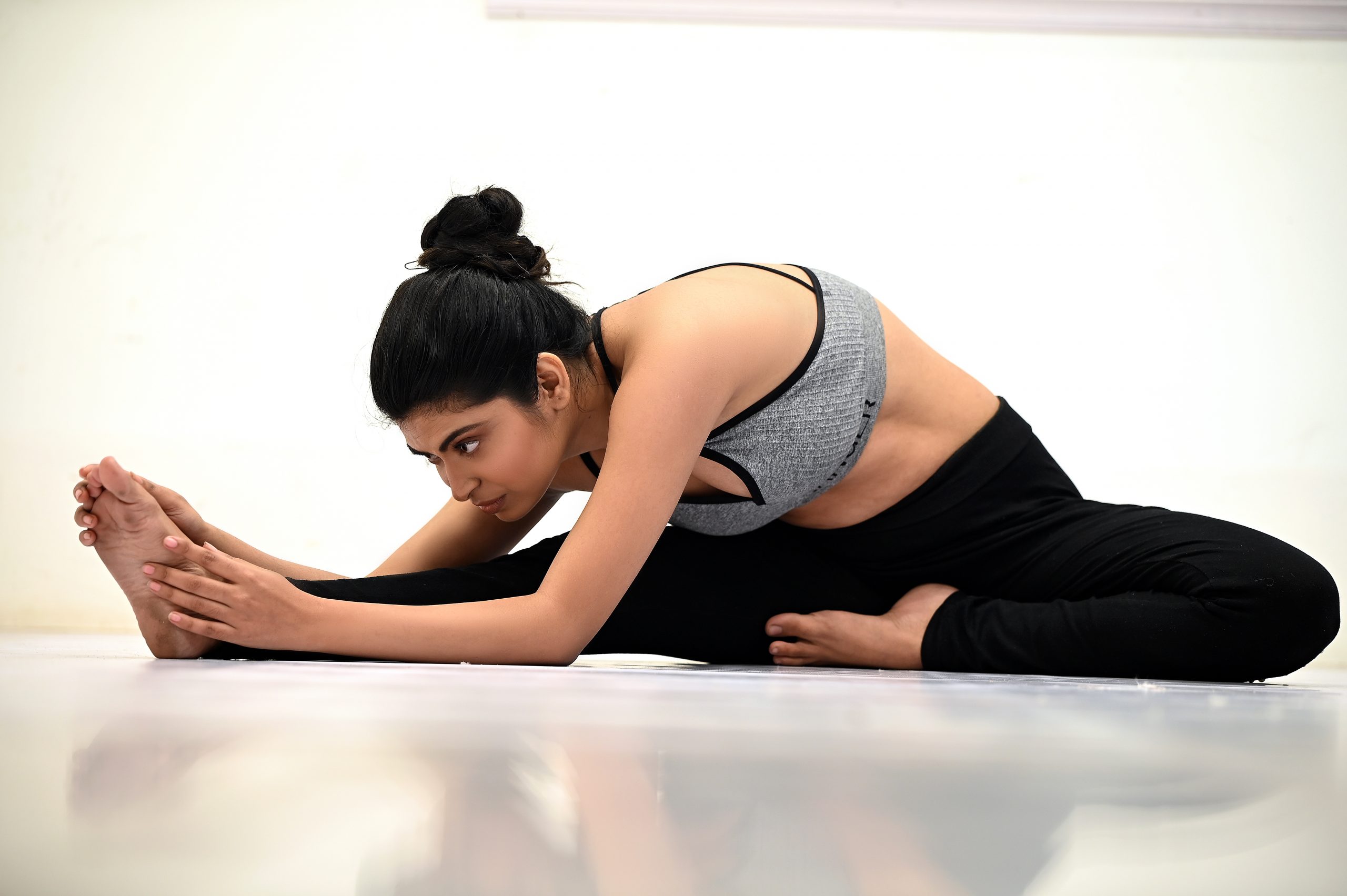 Pregnancy yoga exercise - pregnant woman doing asana Parivrtta janu  sirsasana head to knee pose isolated on white background Stock Photo - Alamy