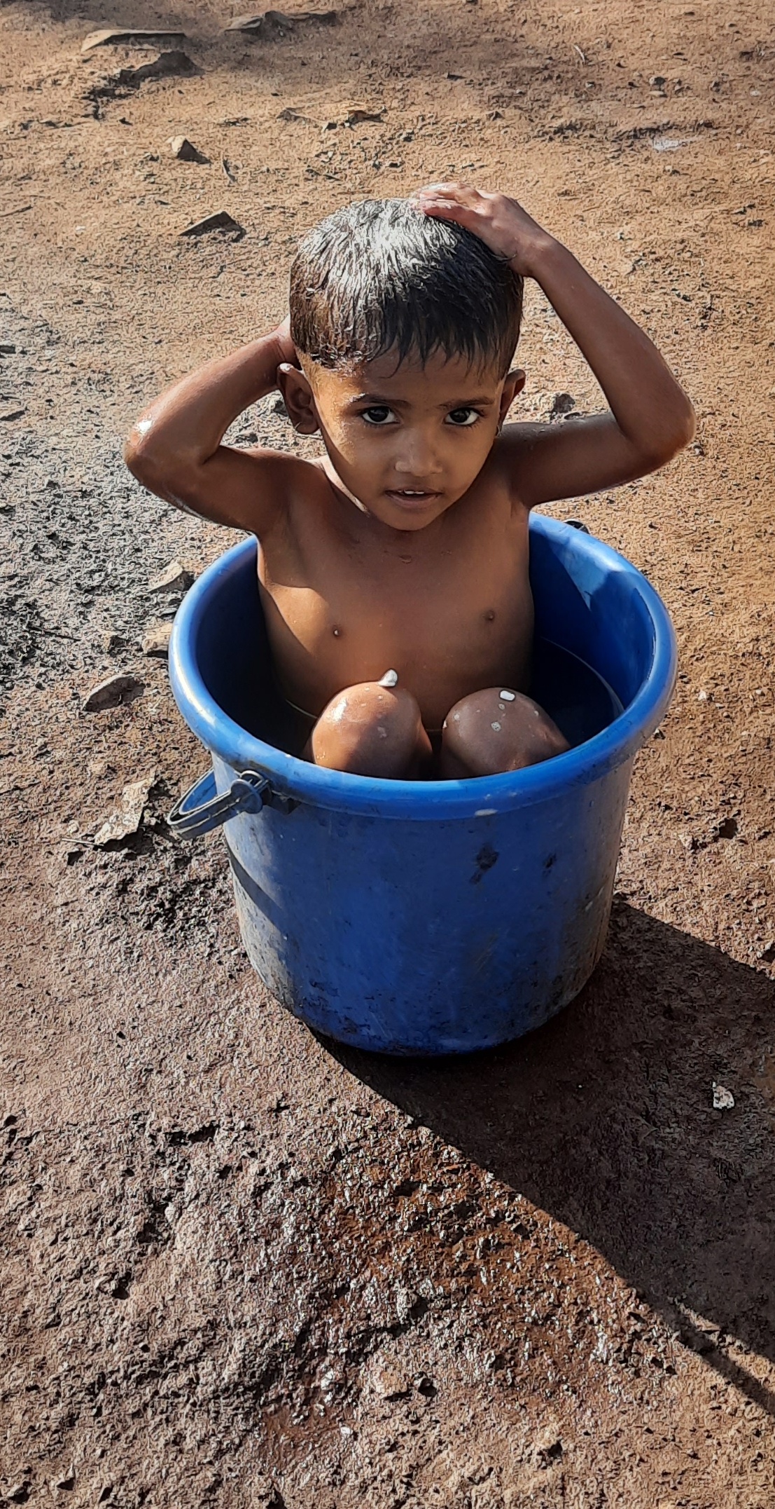 Kid bathing in the the bucket
