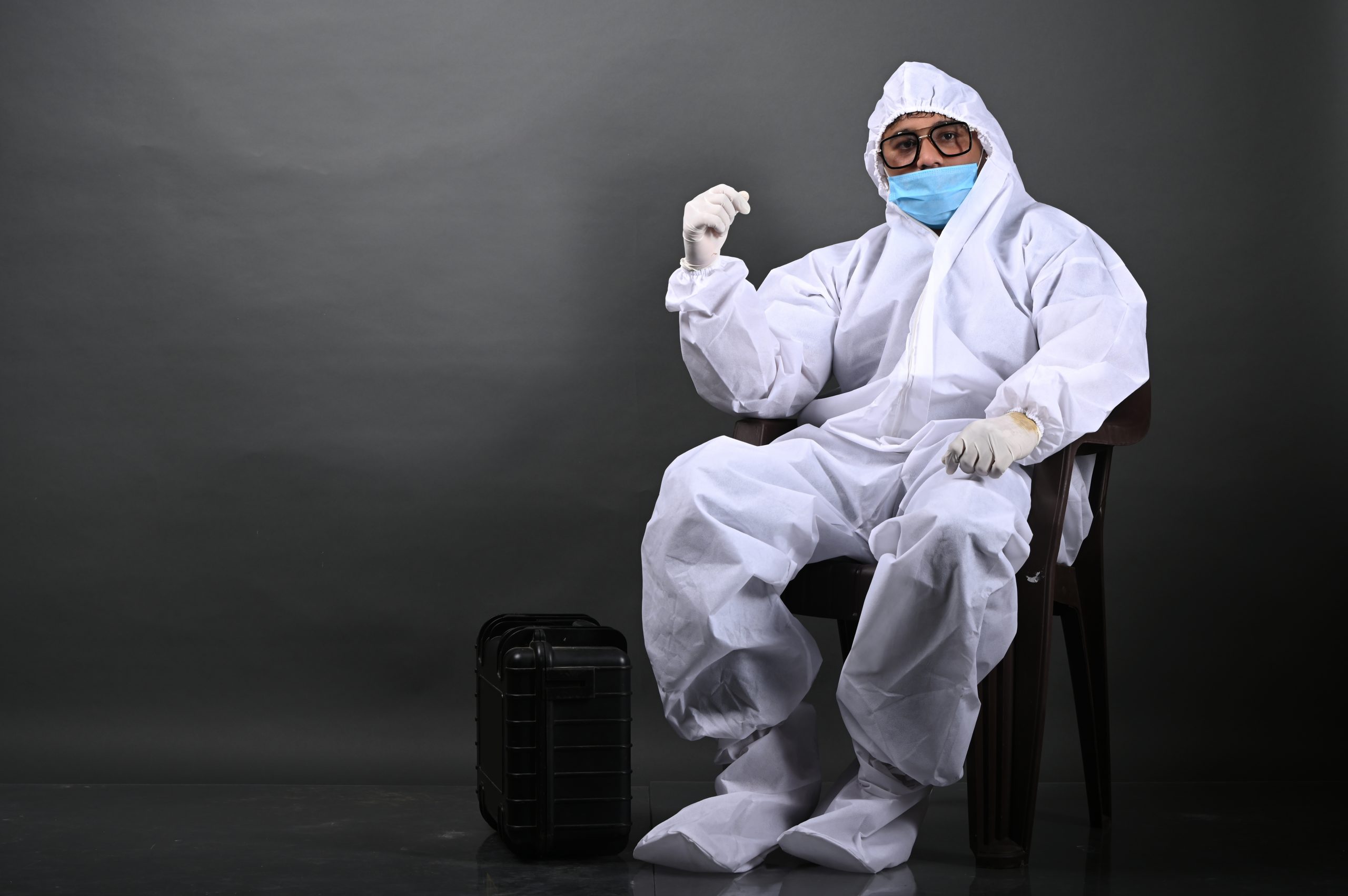 Man sitting on chair in PPE kit