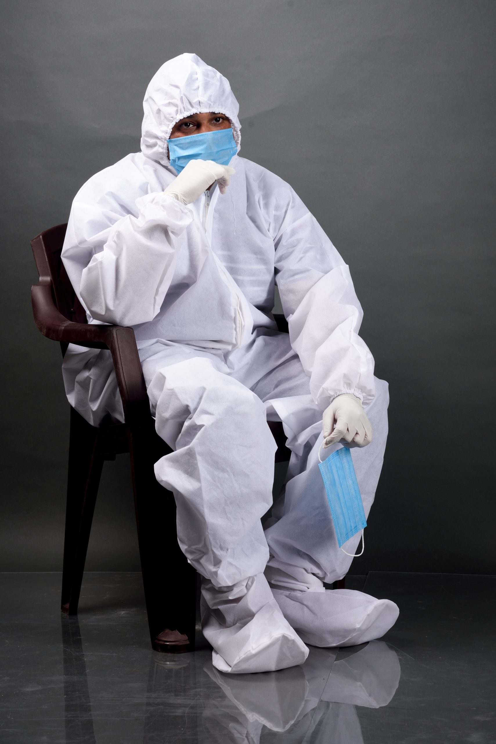 Man on chair in PPE kit