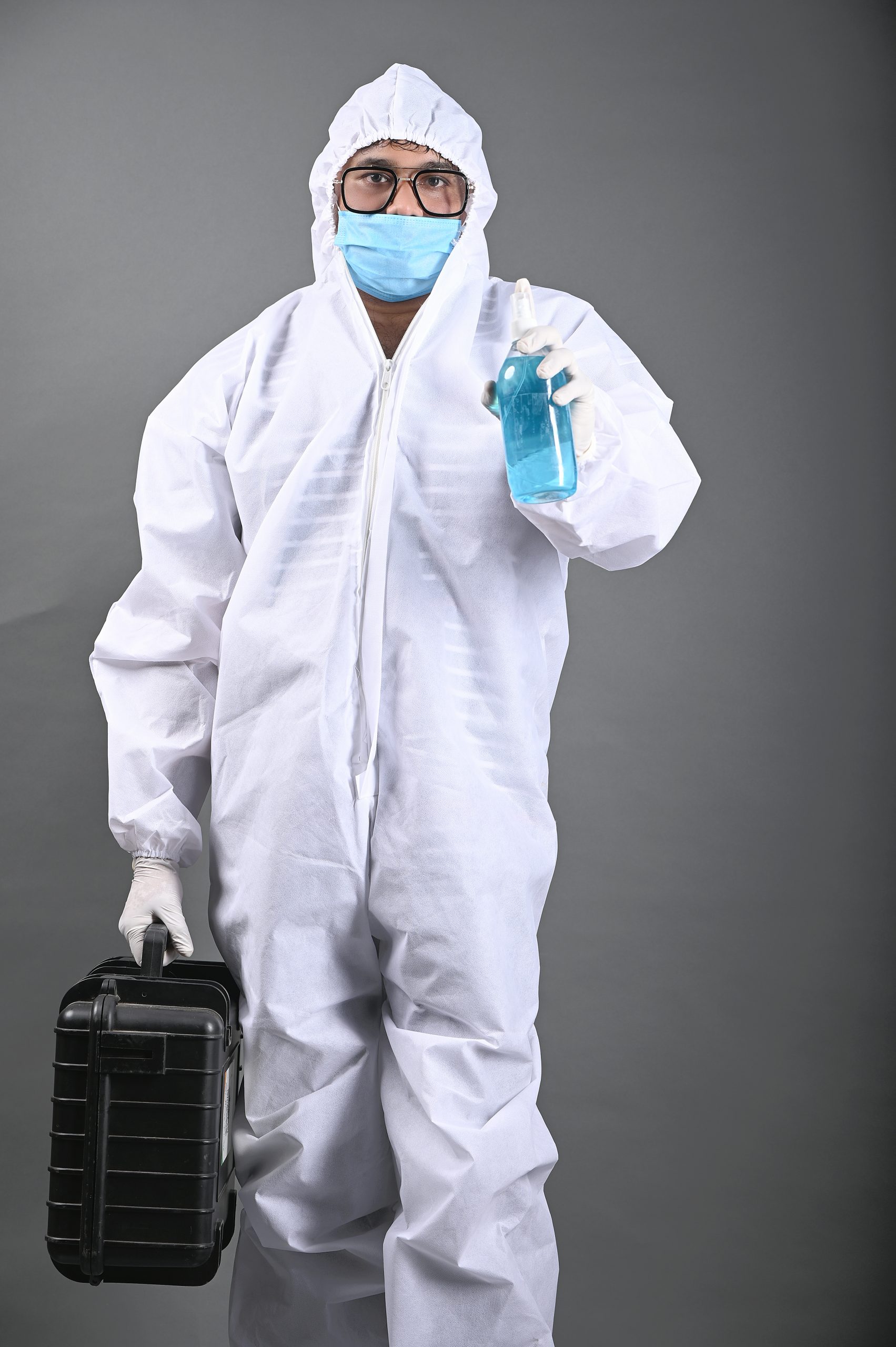 Man wearing PPE kit and holding Sanitizer in hand