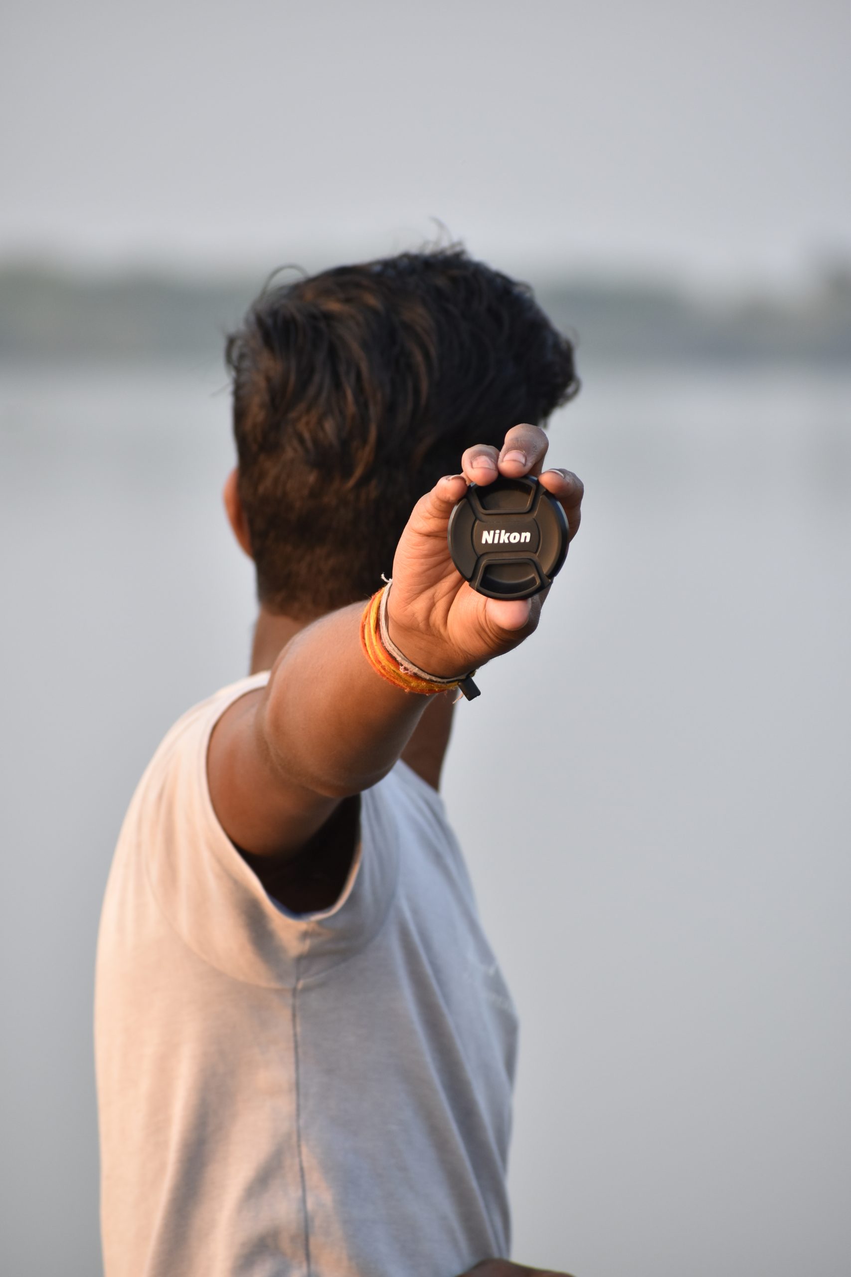 Boy holding camera lens cap