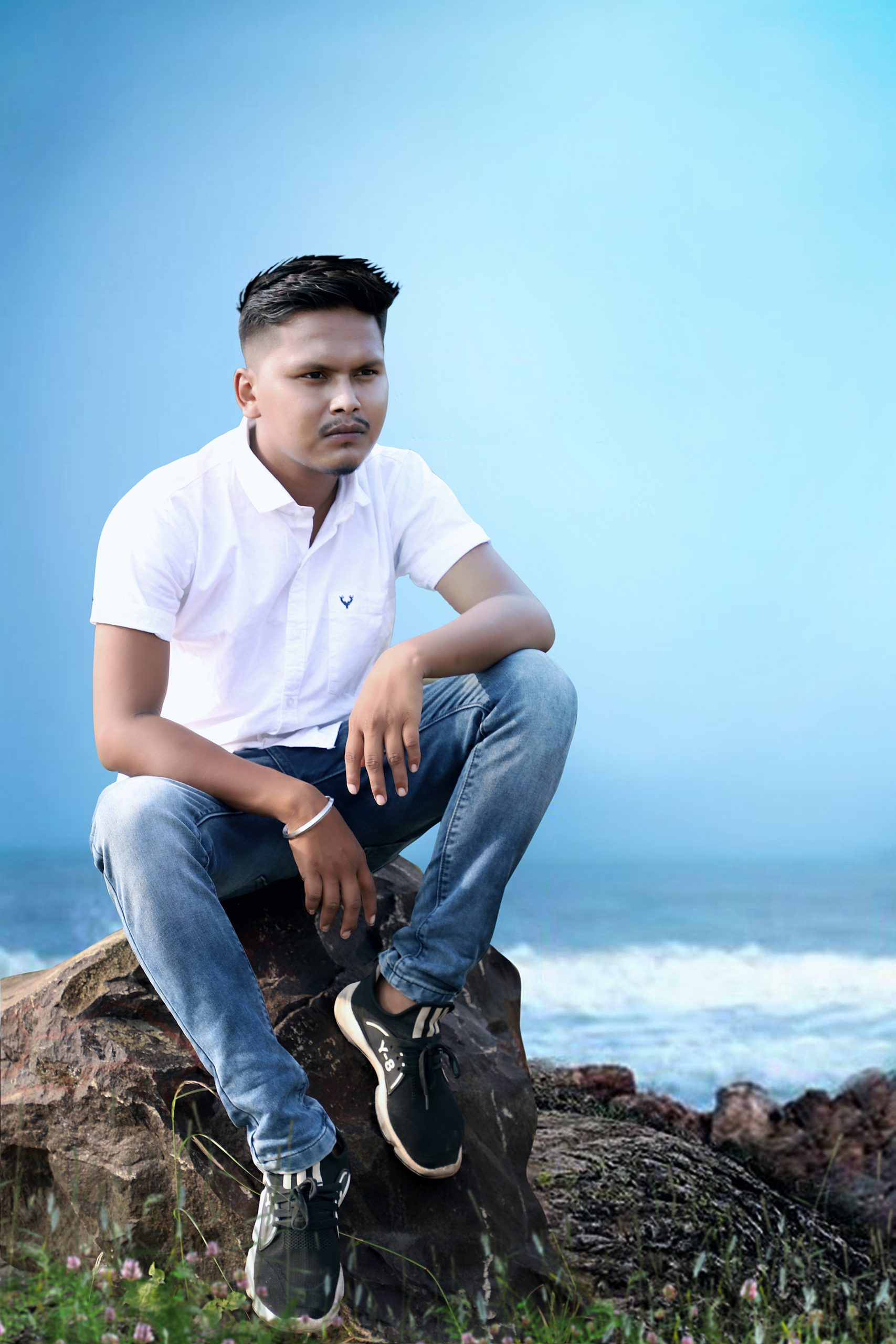 Boy sitting on rock near the beach