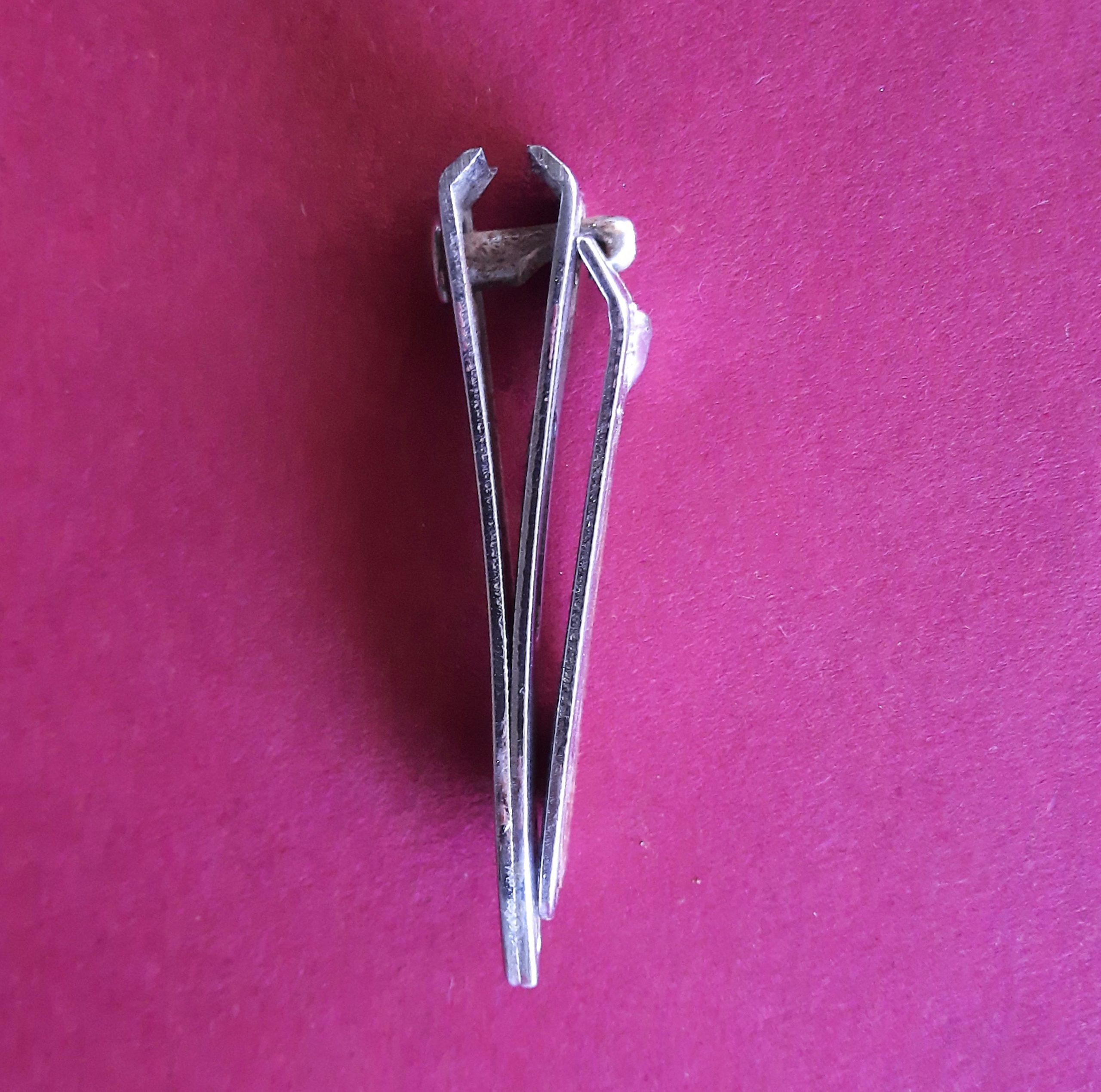 Nail cutter lying on a pink backgroung