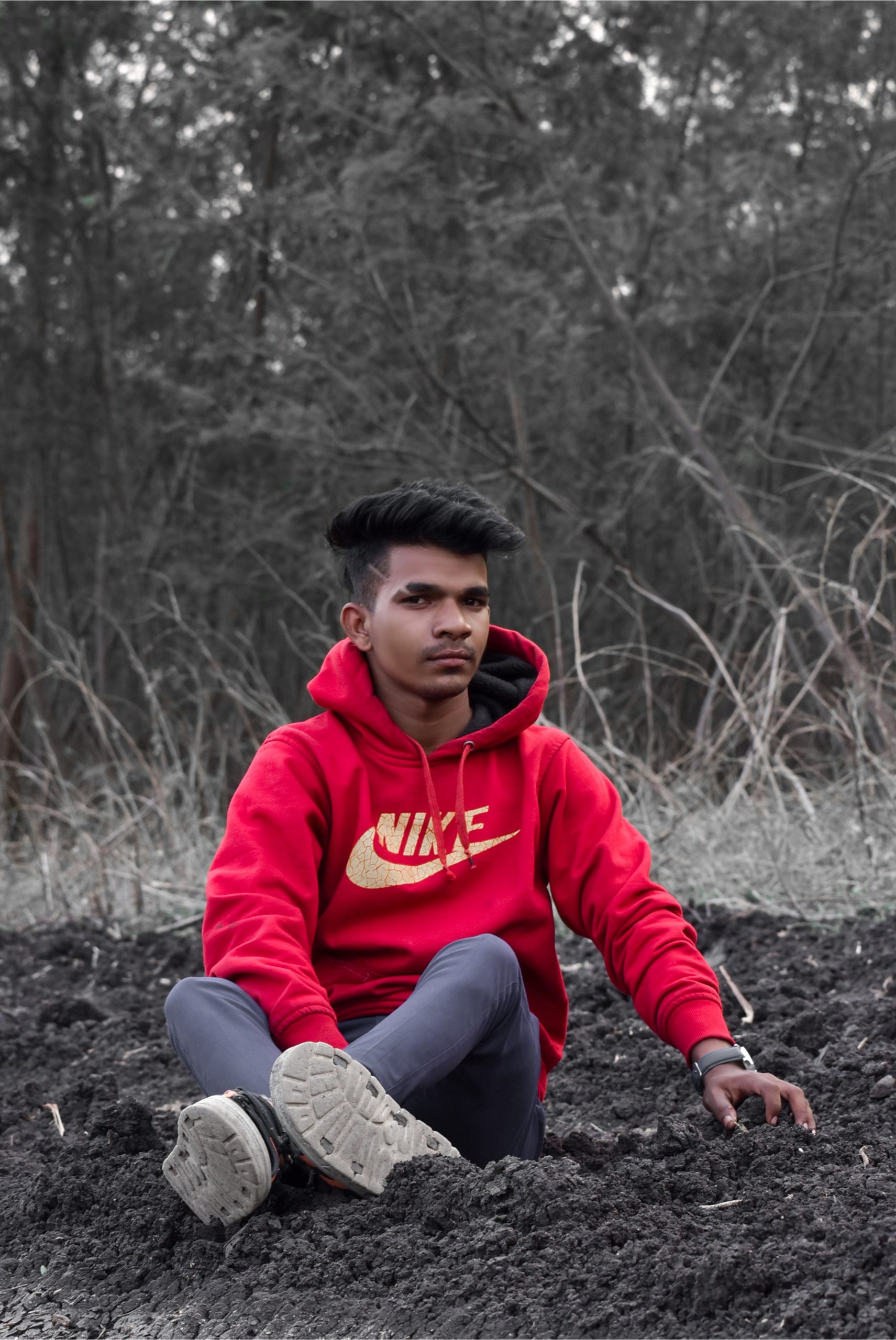 A boy sitting on soil