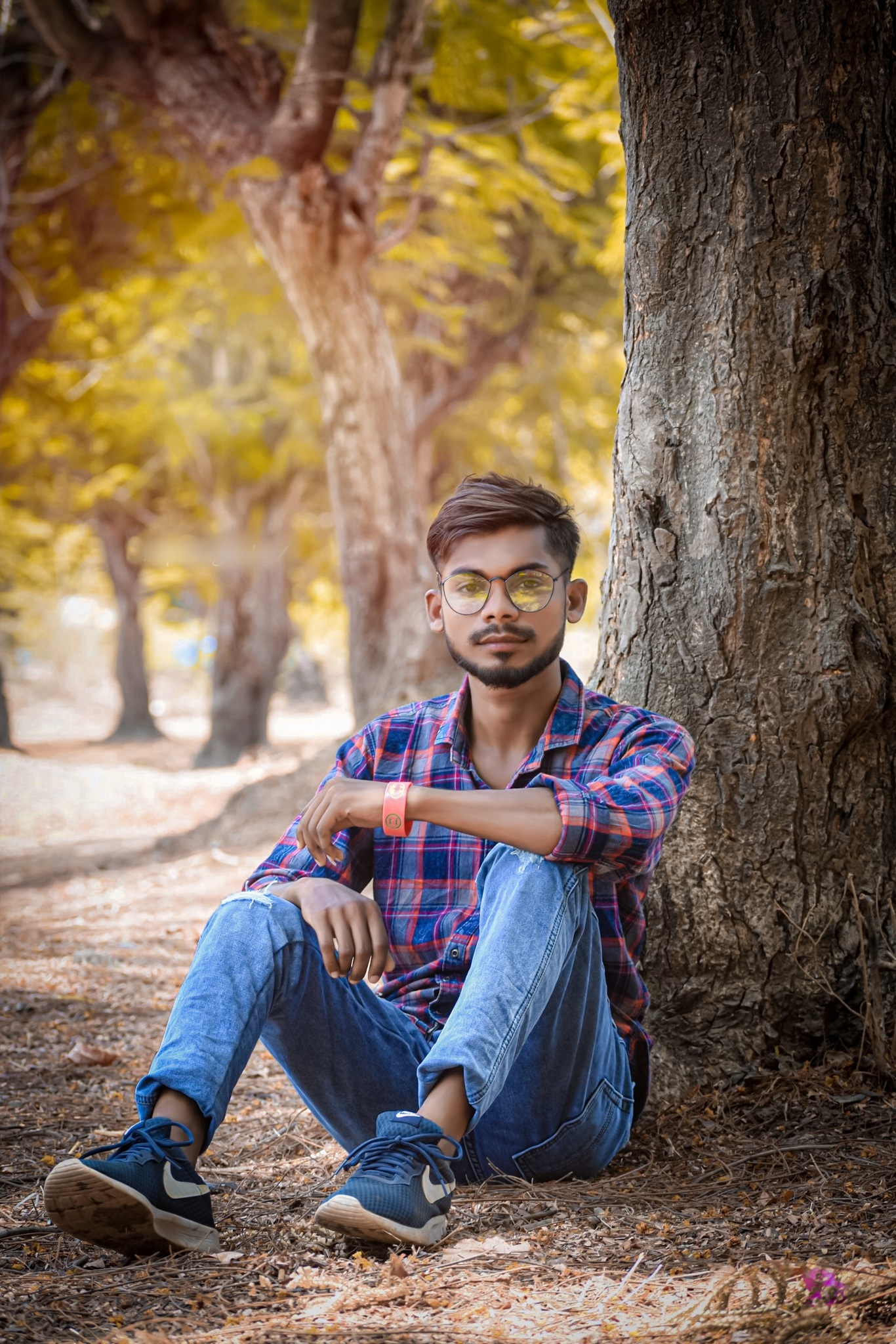 A boy sitting under a tree