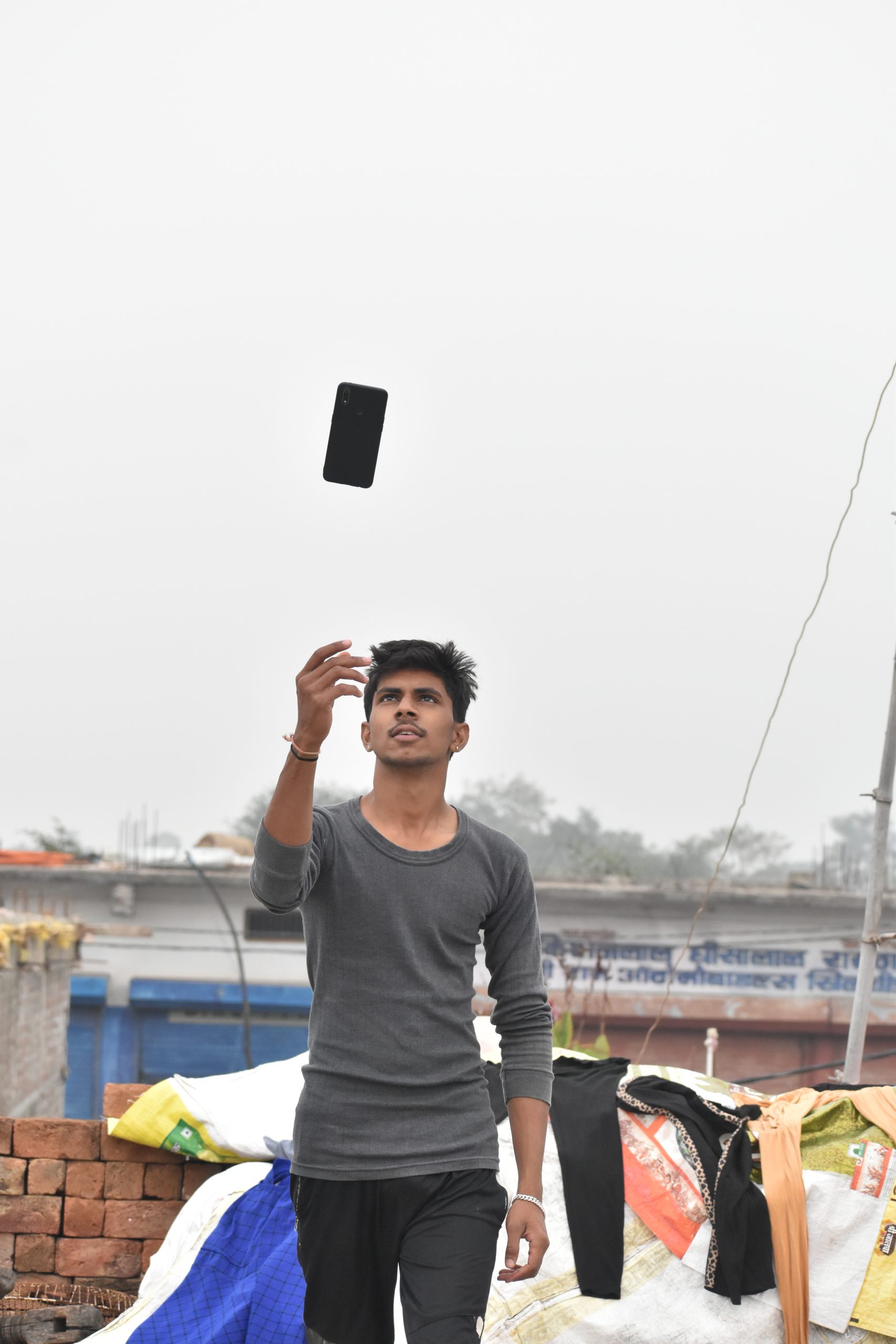 A boy tossing his phone in air
