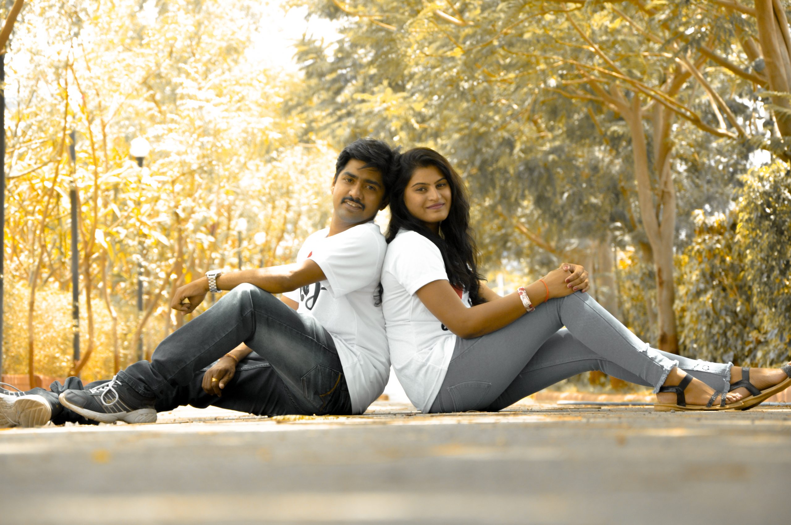 A young romantic couple sitting and posing in a park Stock Photo - Alamy