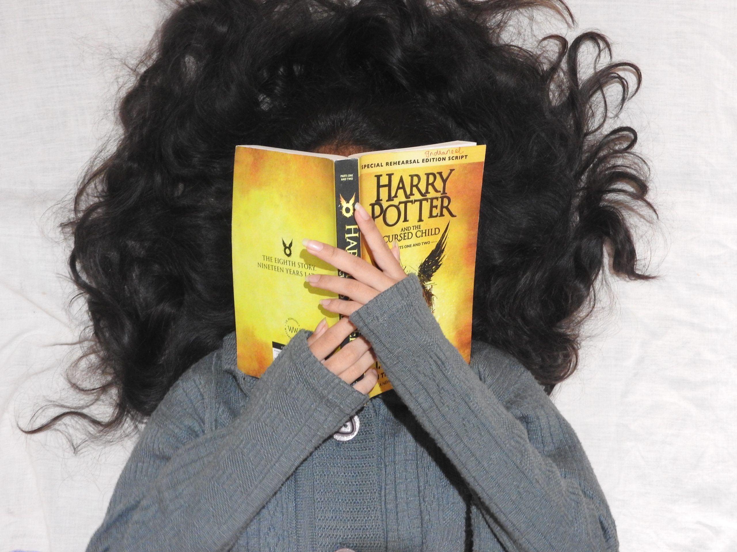 Girl hiding her face with harry potter book