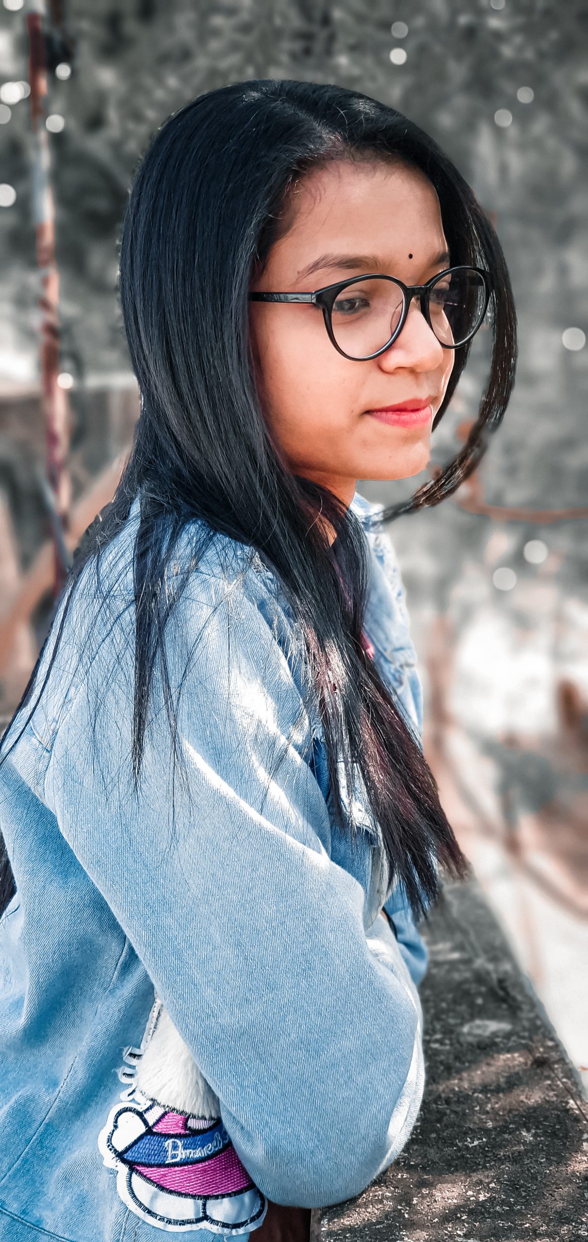 Girl posing near the wall in specs