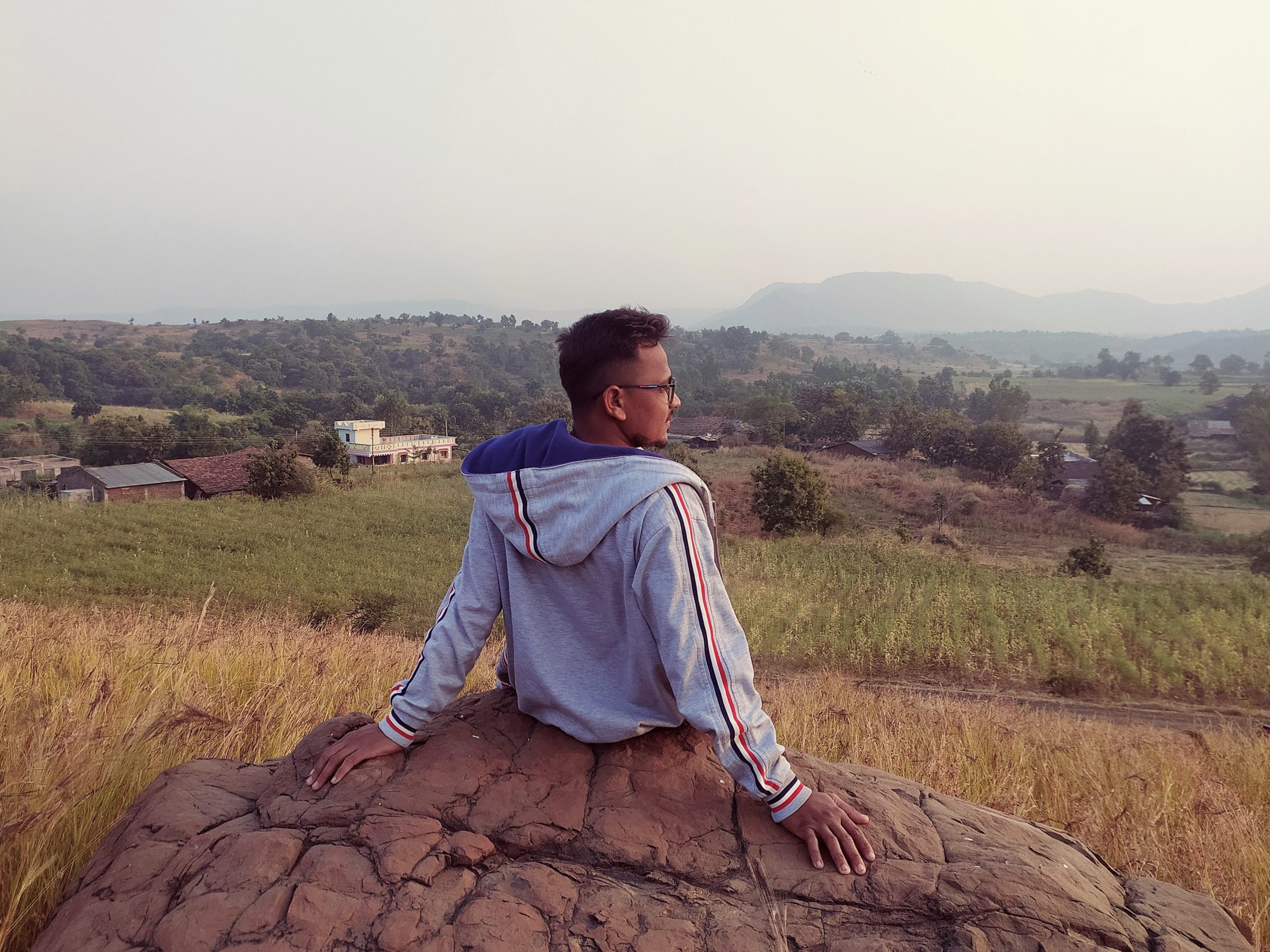 Man sitting on the rock in farm