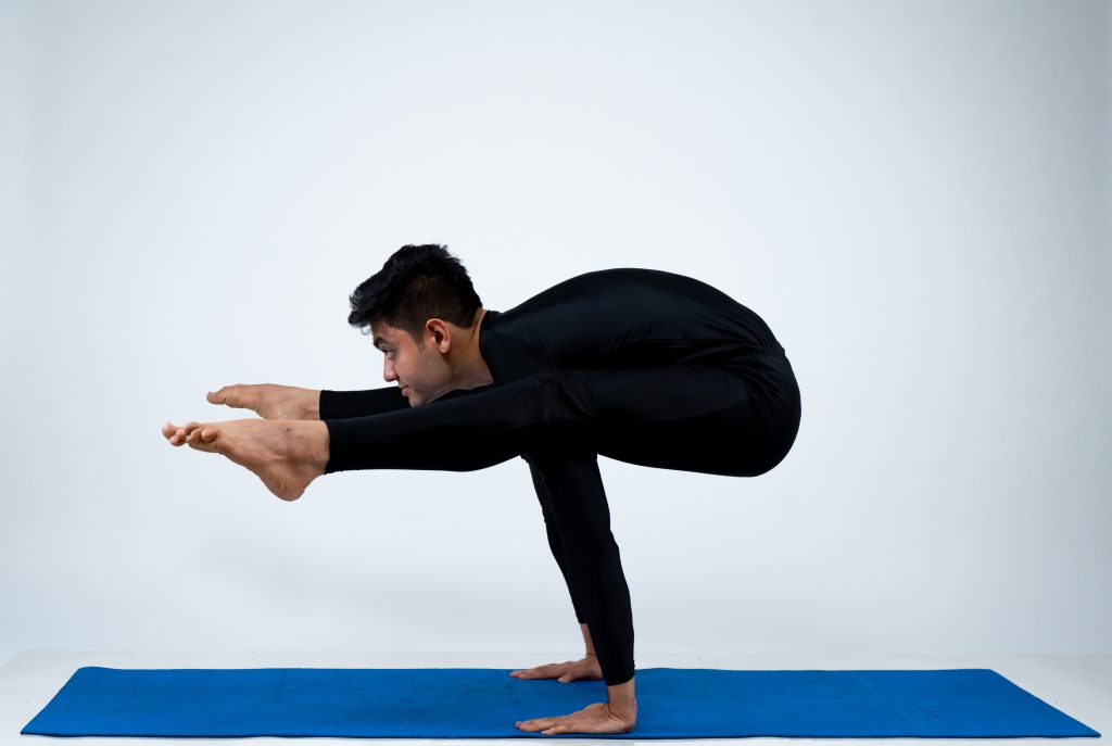 Premium Photo | Contented woman in sportswear practicing yoga performs  tittibhasana firefly pose in the studio