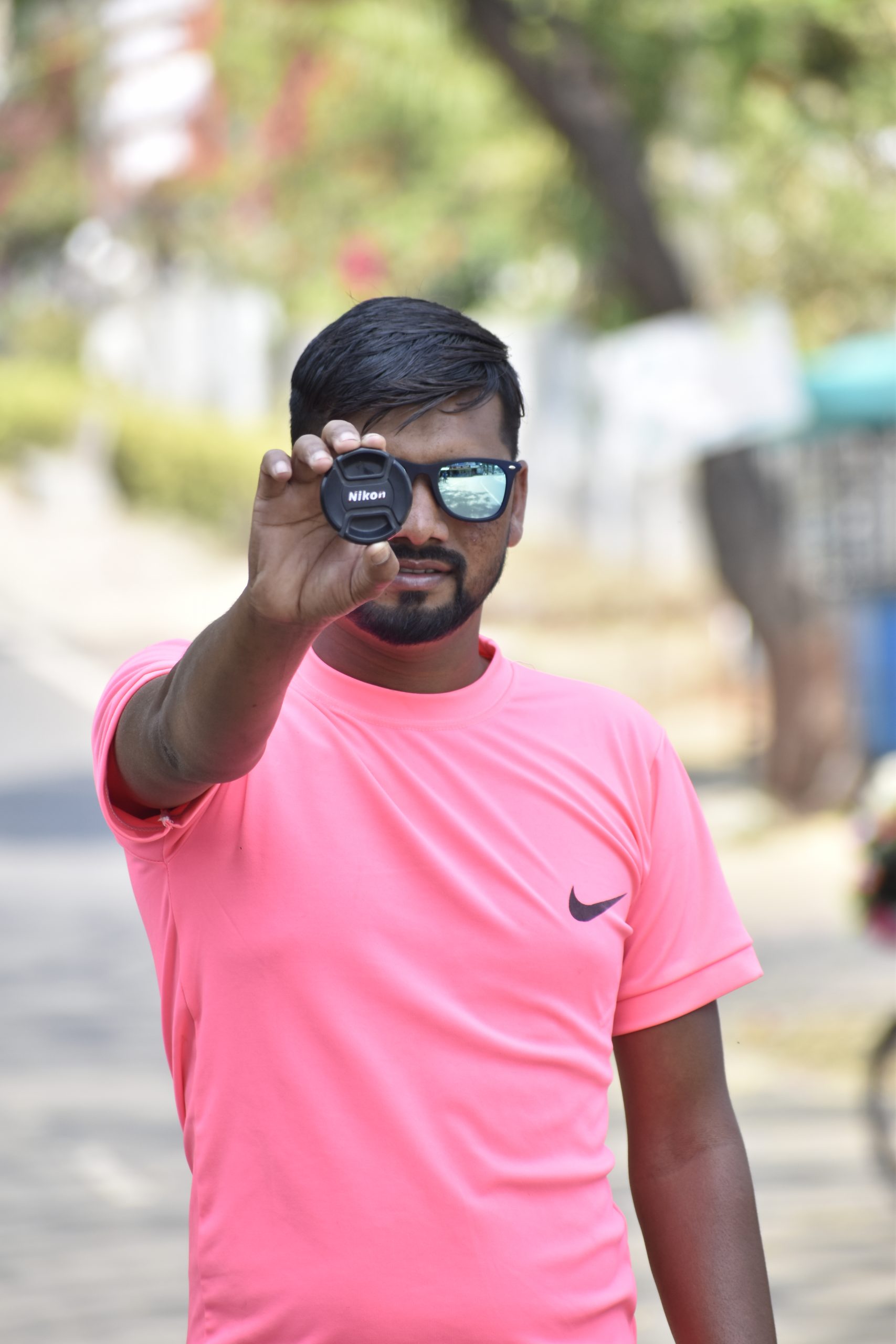 A boy showing camera lens cap