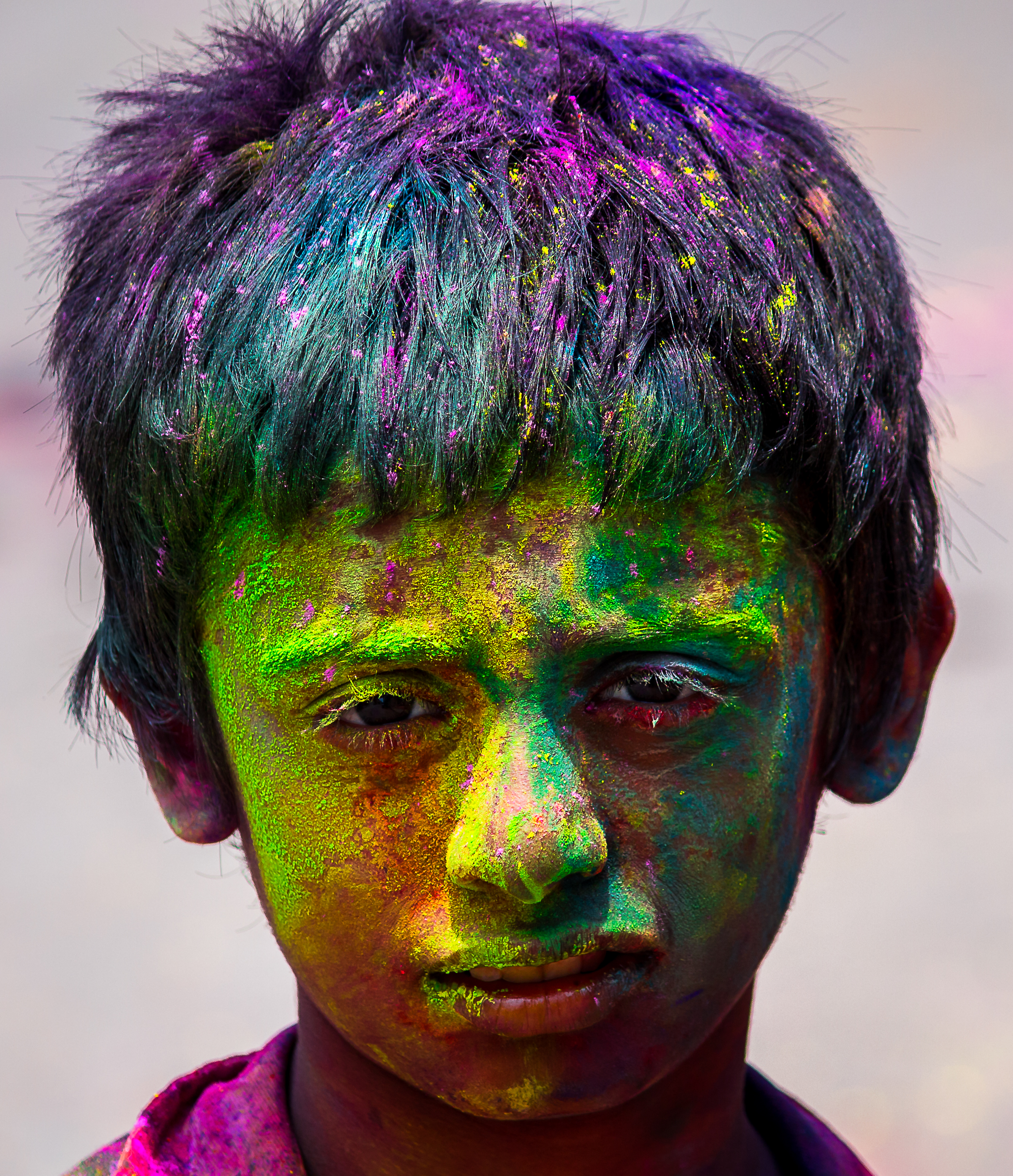 A child's face painted with Holi colors