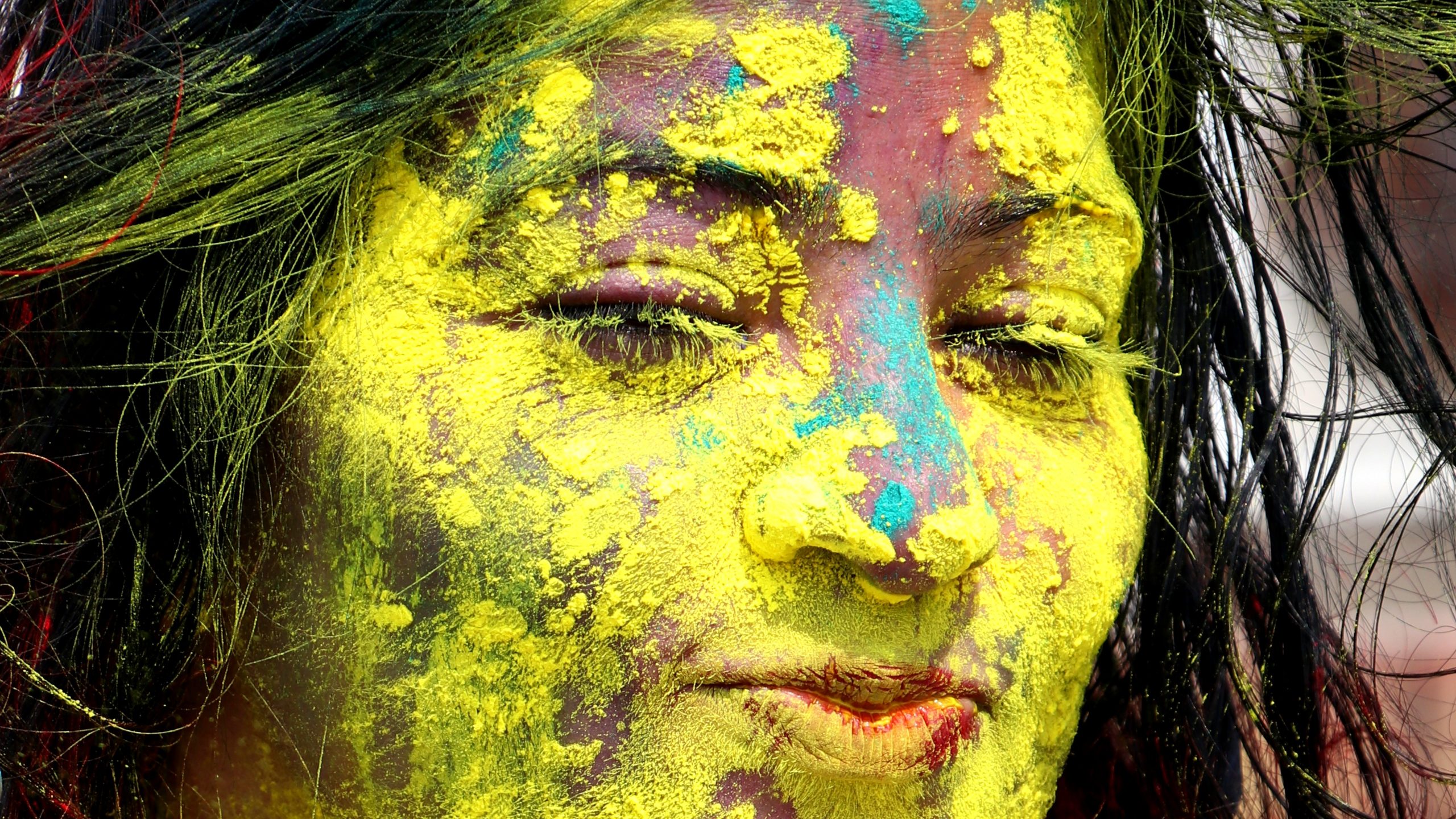A girl's face painted with Holi colors