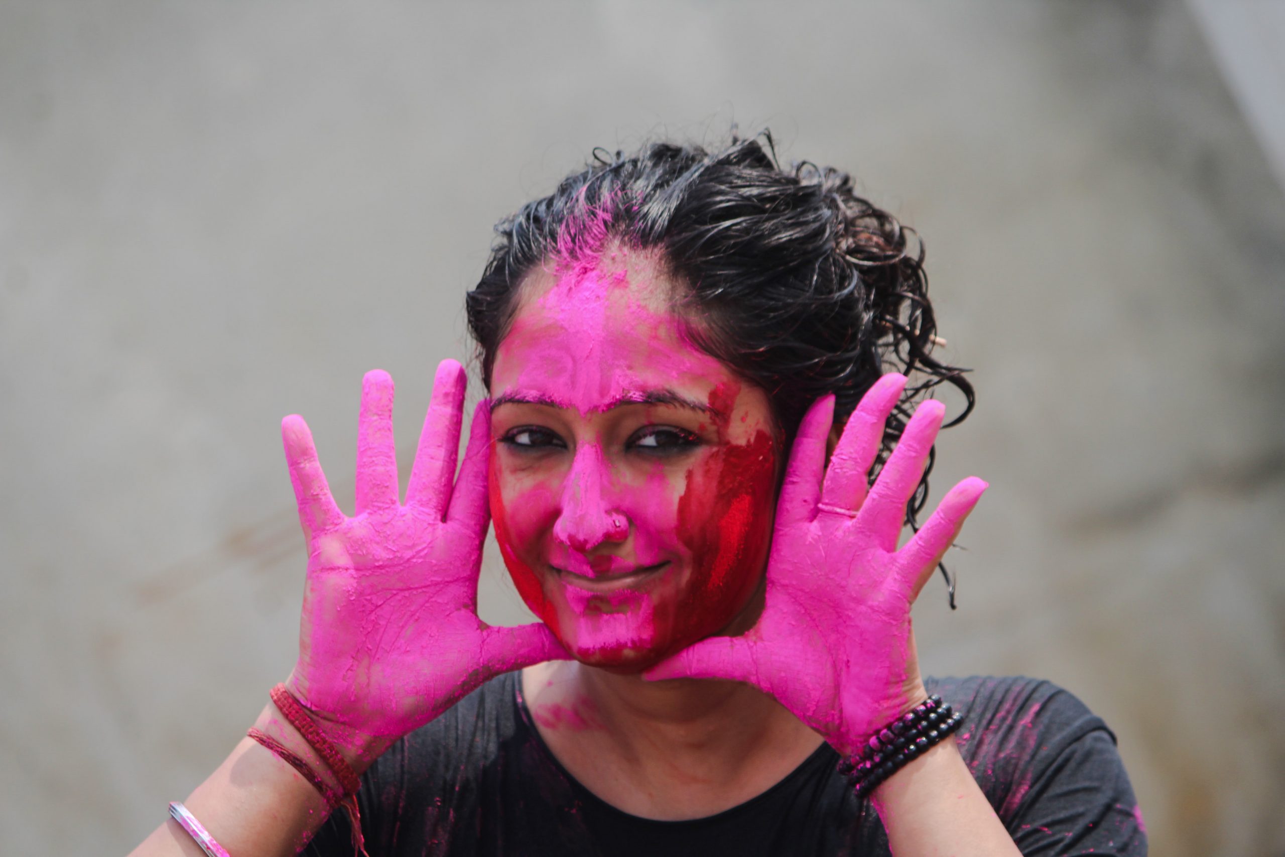 A girl's hands and face painted with Holi colors