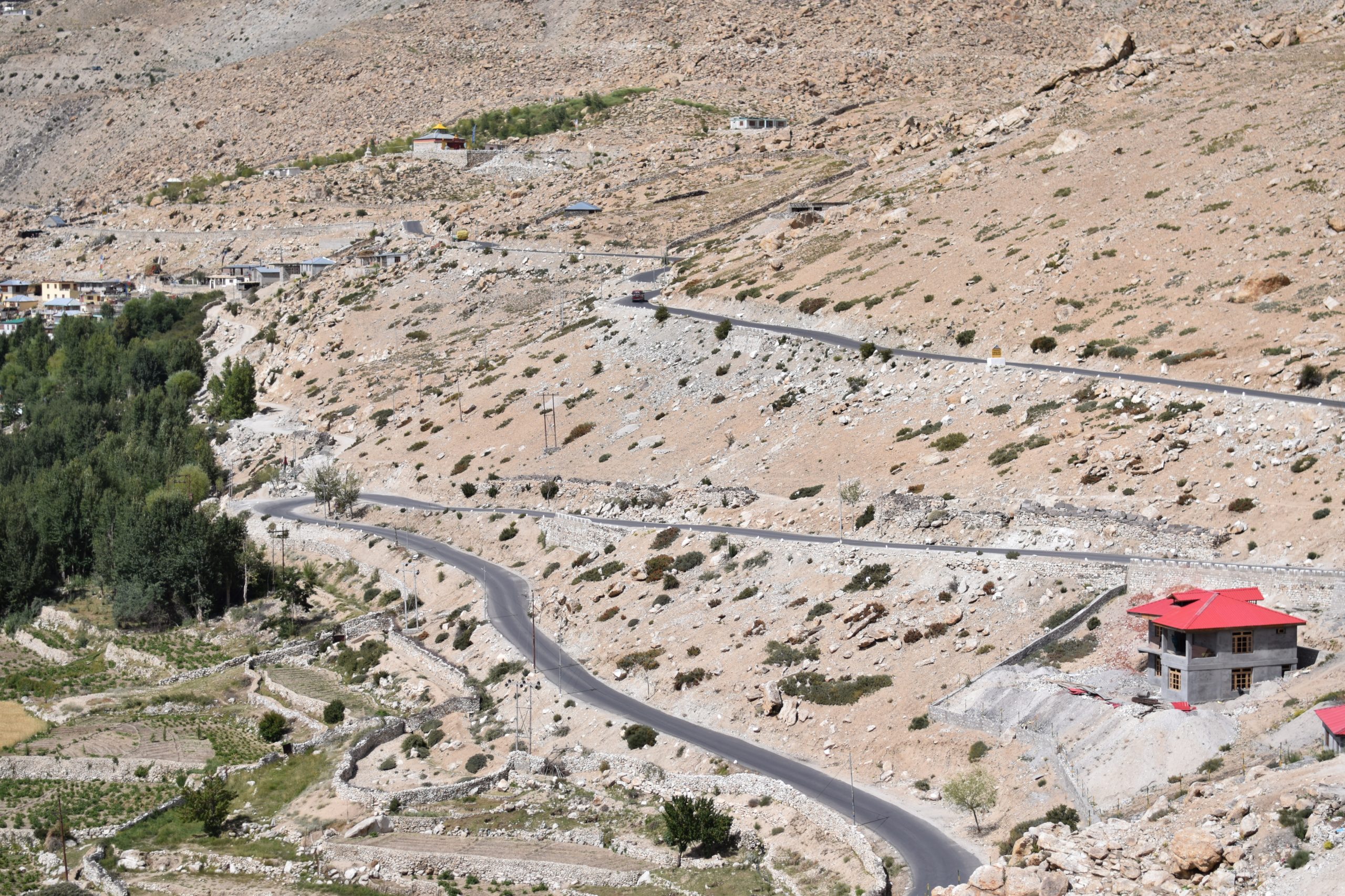 A road curves on a barren mountain