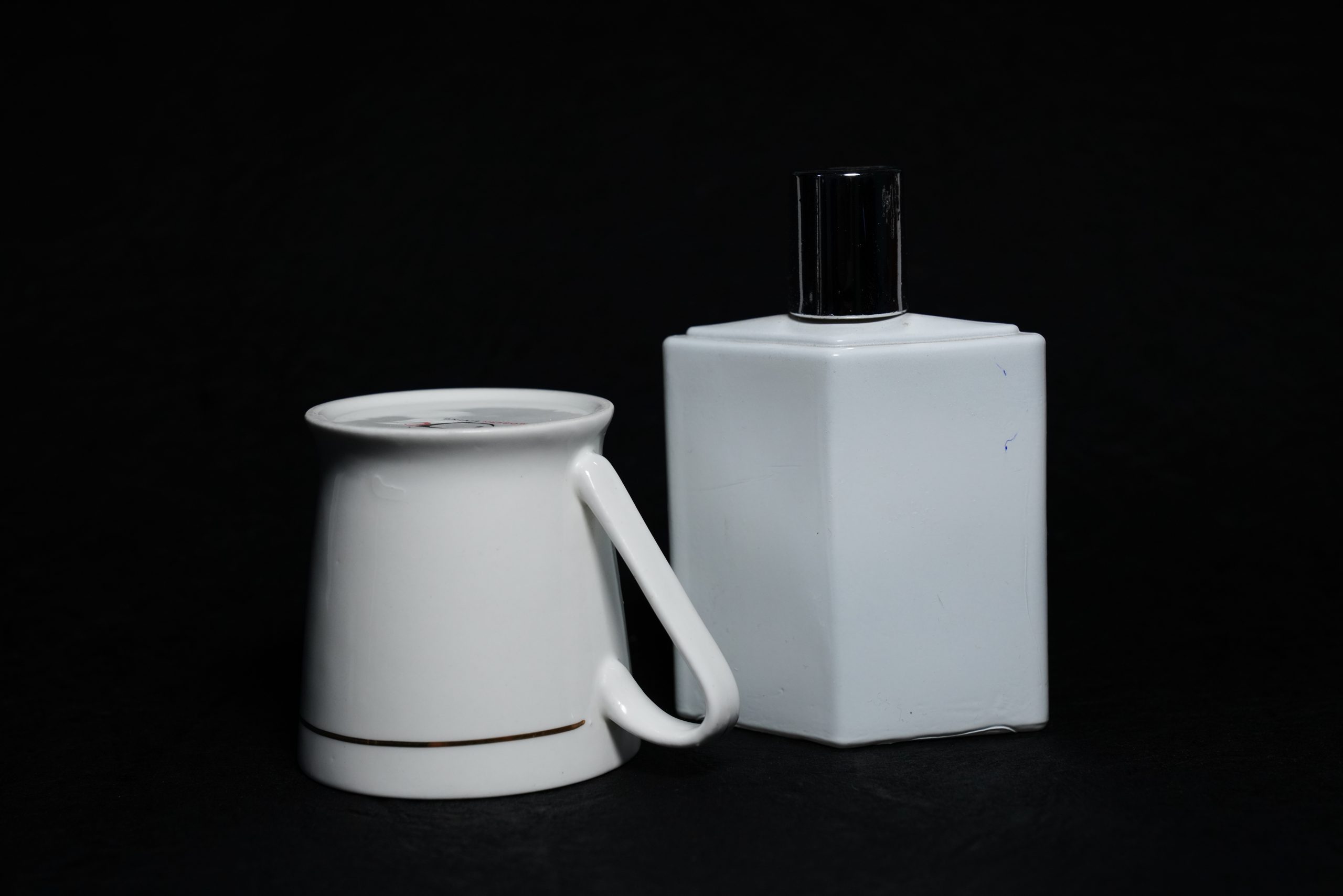 A tea cup and perfume bottle