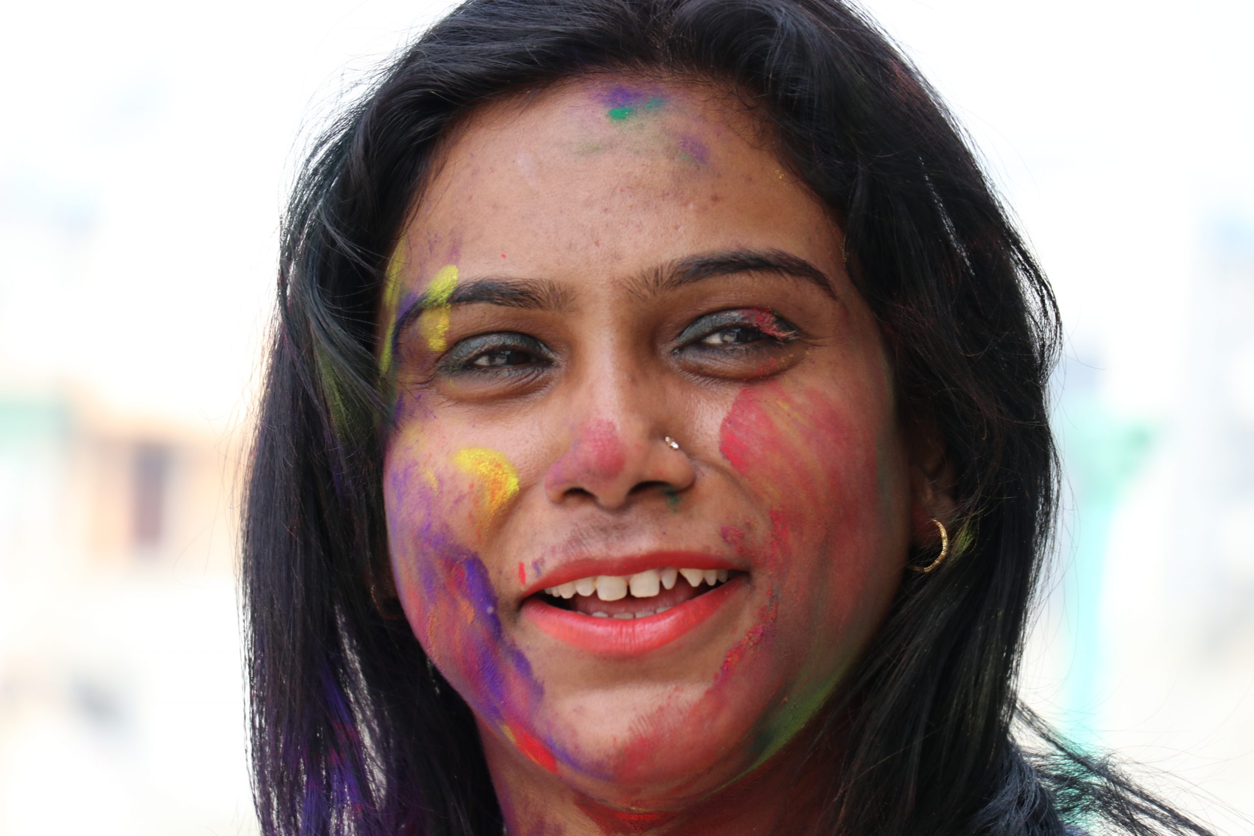 A woman face painted with Holi colors