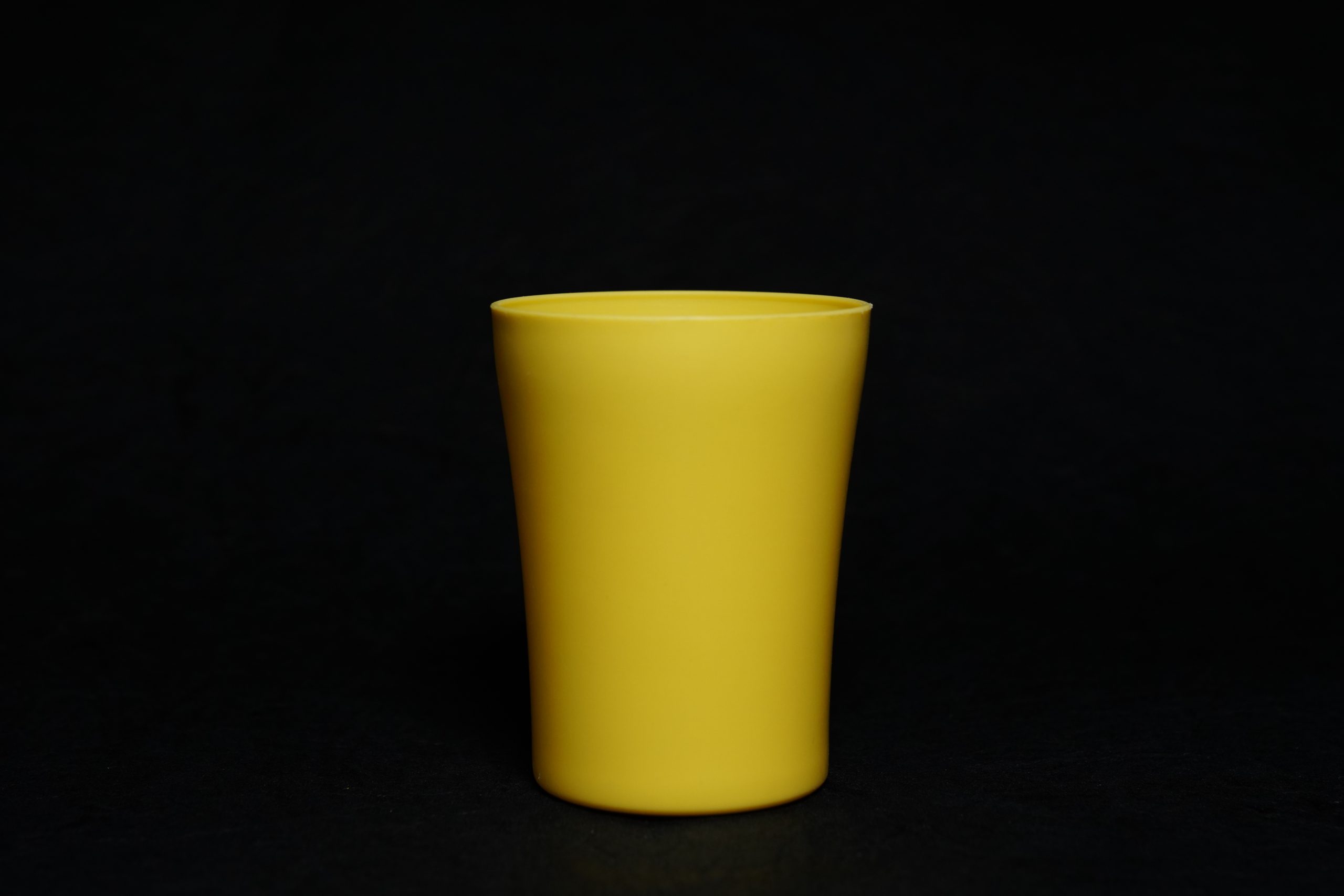 A yellow glass with black background