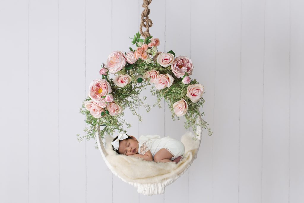Baby sleeping in the swing decorated with roses PixaHive