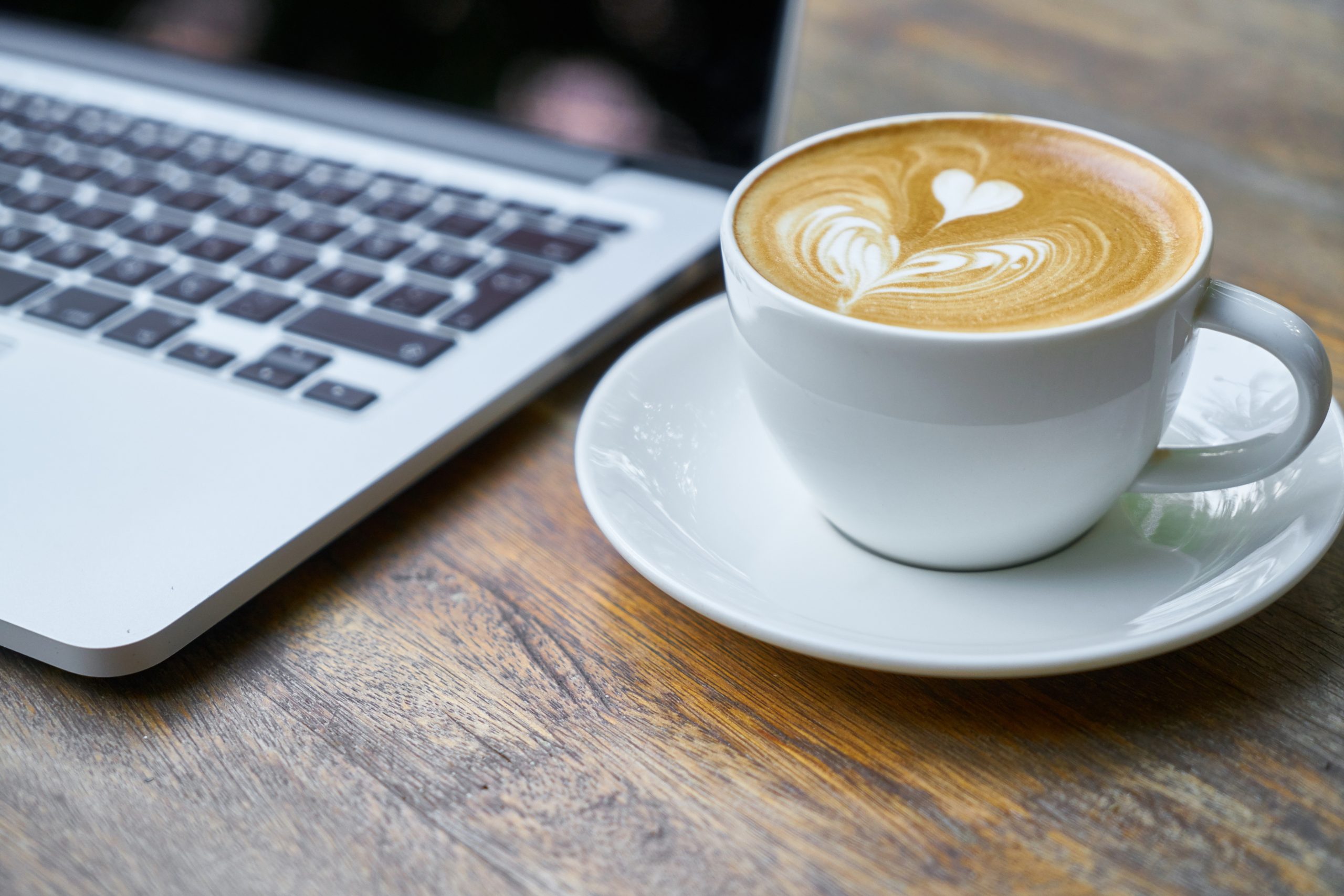 Coffee near the laptop on desk