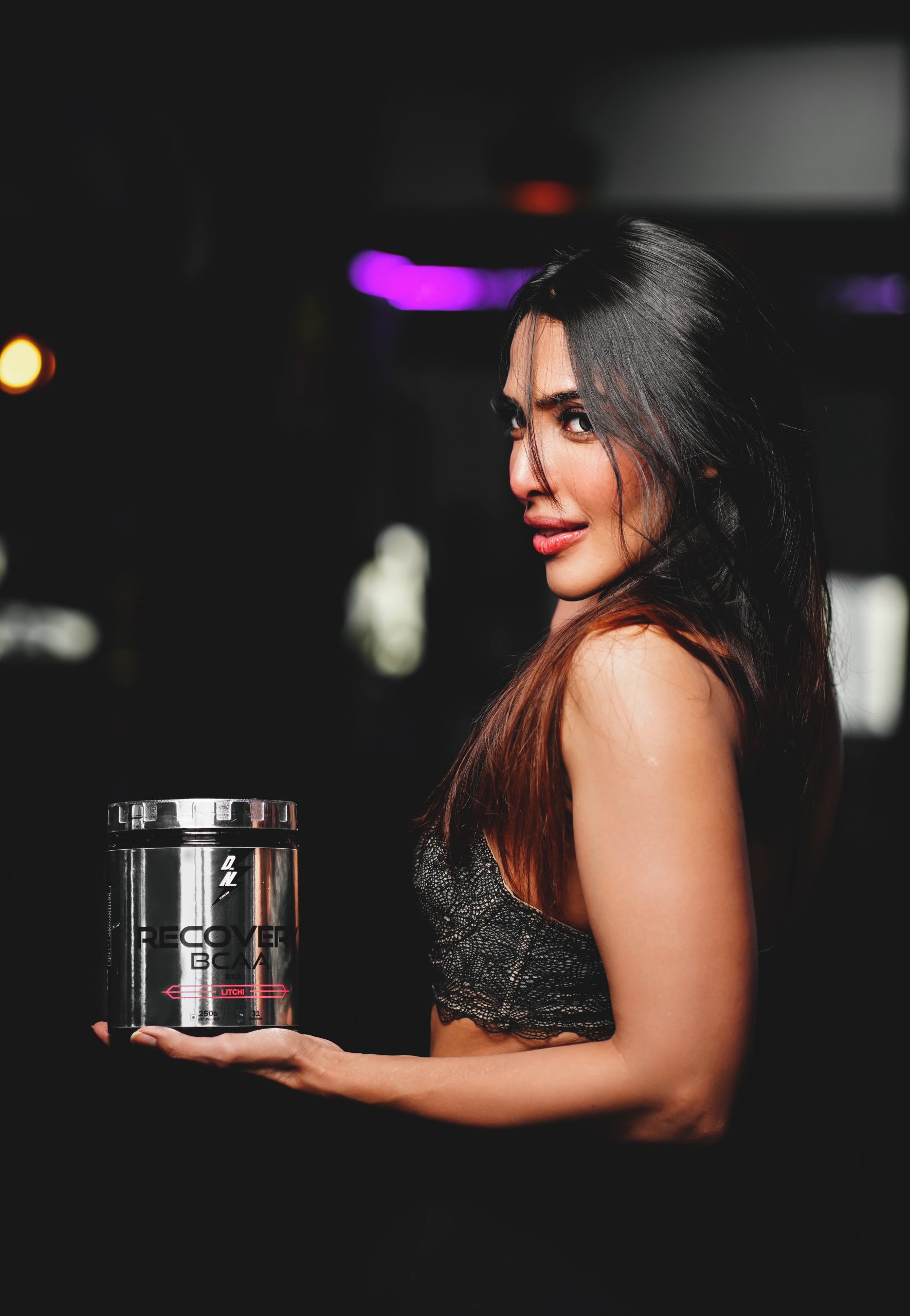 Female gym model showing supplement product