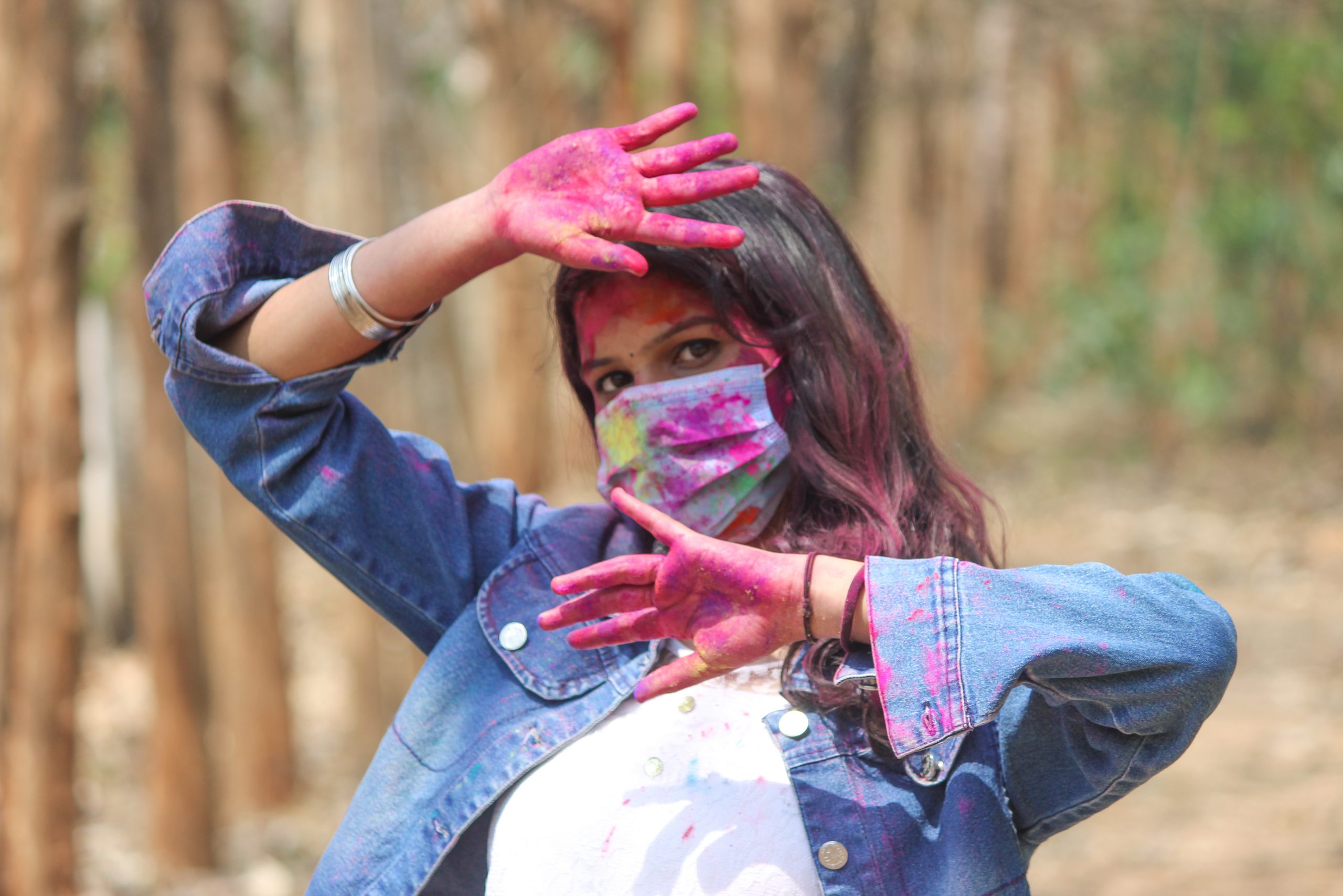 A girl with face mask celebrating Holi festival