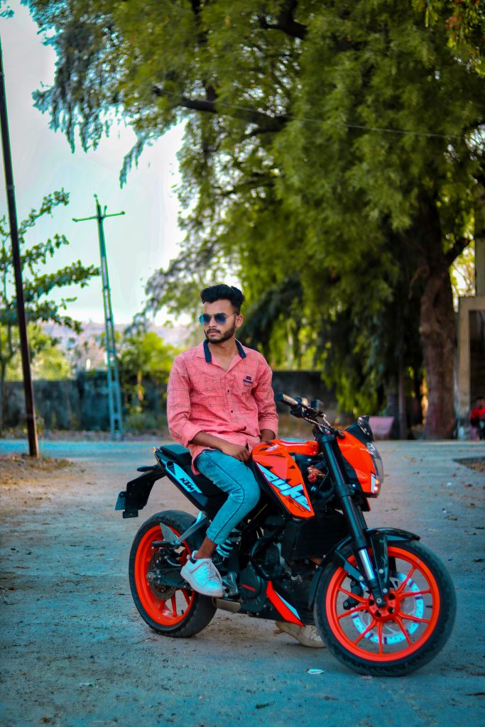 Premium Photo | Vertical image of thoughful biker wears sunglasses rides  motorbike in park poses on street wears stylish clothing enjoys spare time  and hobby admires nature enjoys sunny autumnal weather