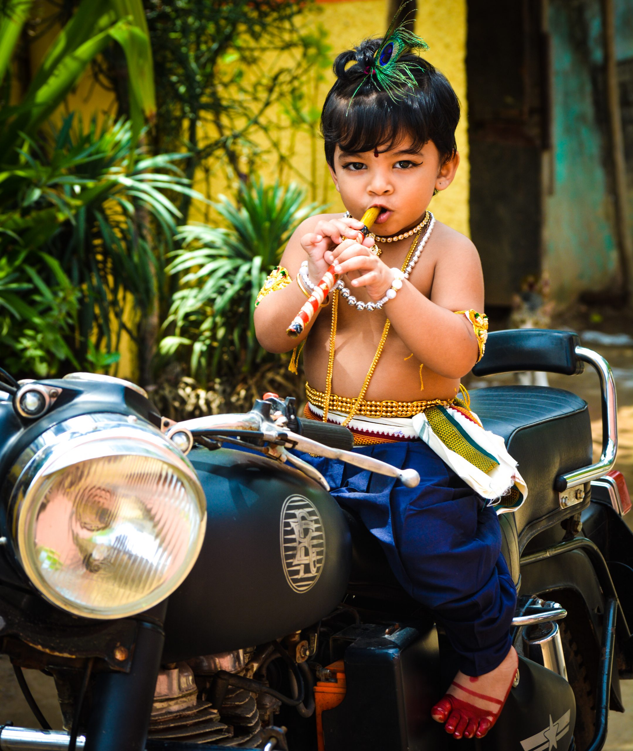 Little baby in Krishna Avtar on Royal Enfield bike