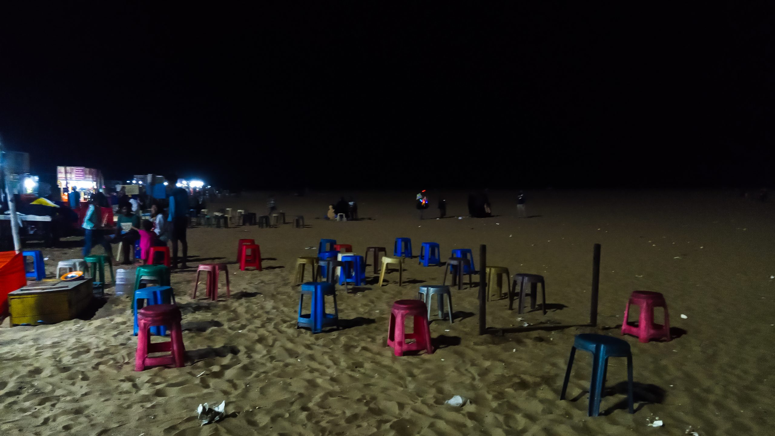 Plastic stools on beach at night