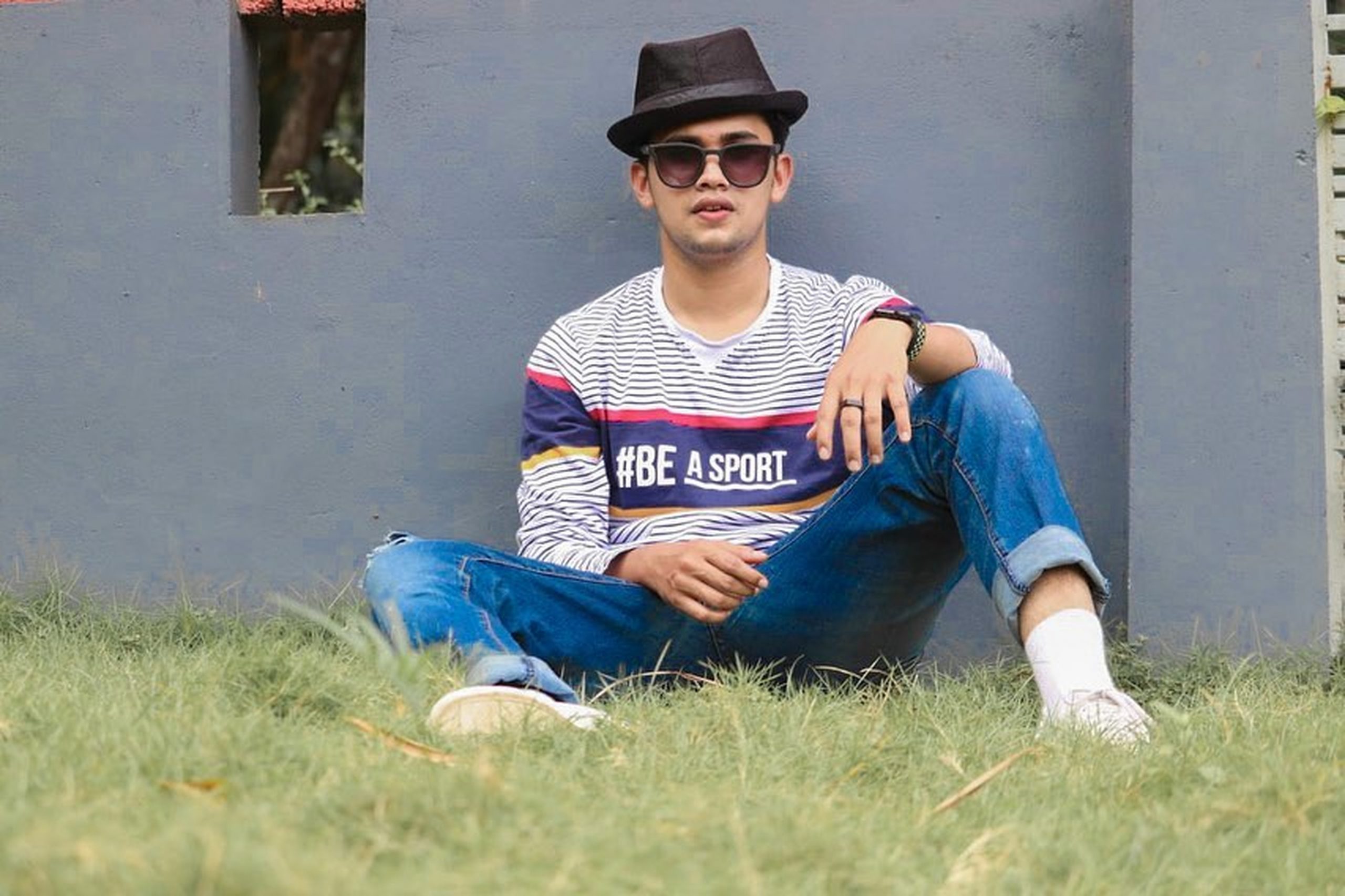A stylish boy sitting on grass